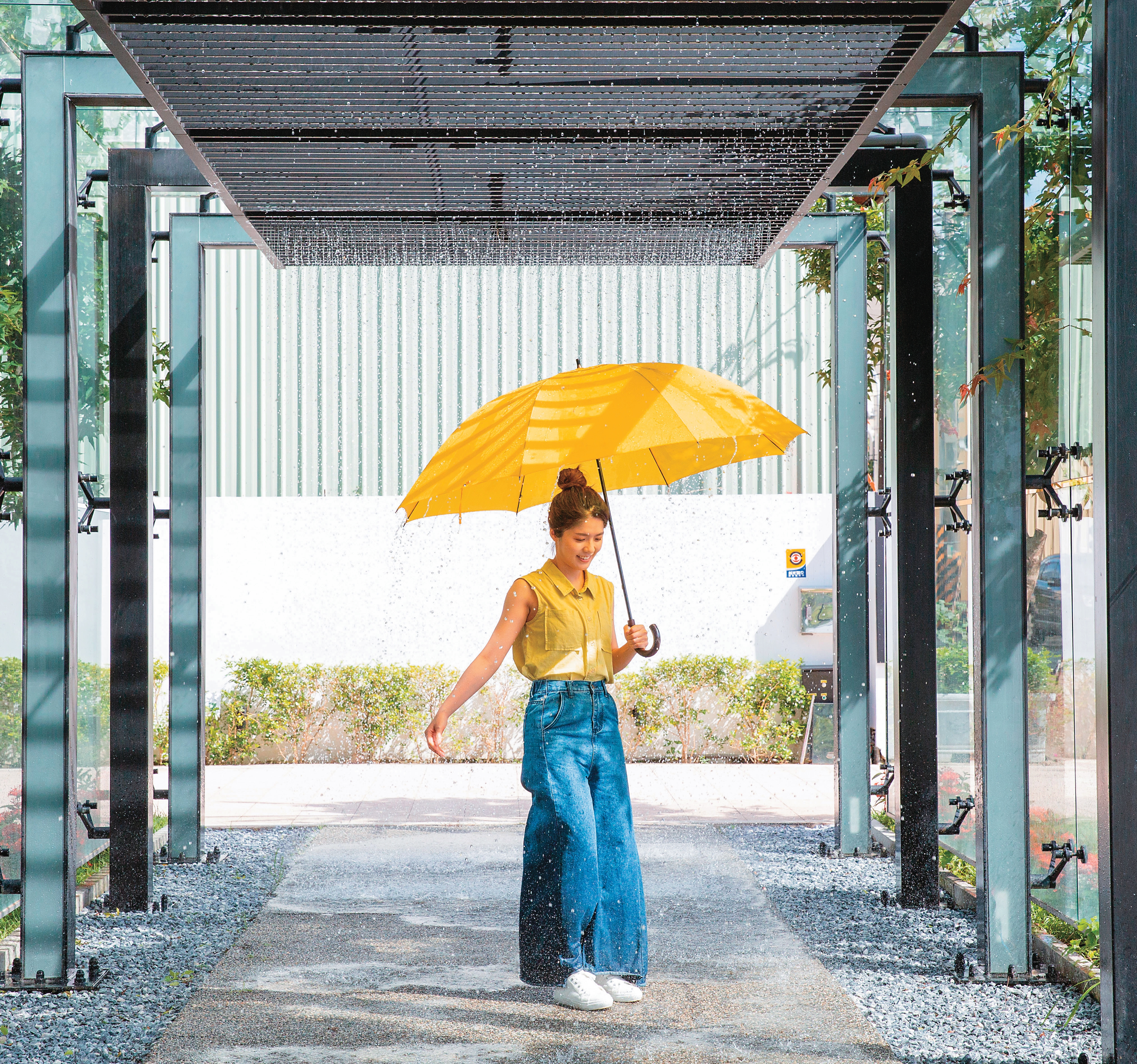 降雨體驗廊道中，撐一把大傘，感受強、弱雨量的降雨程度。