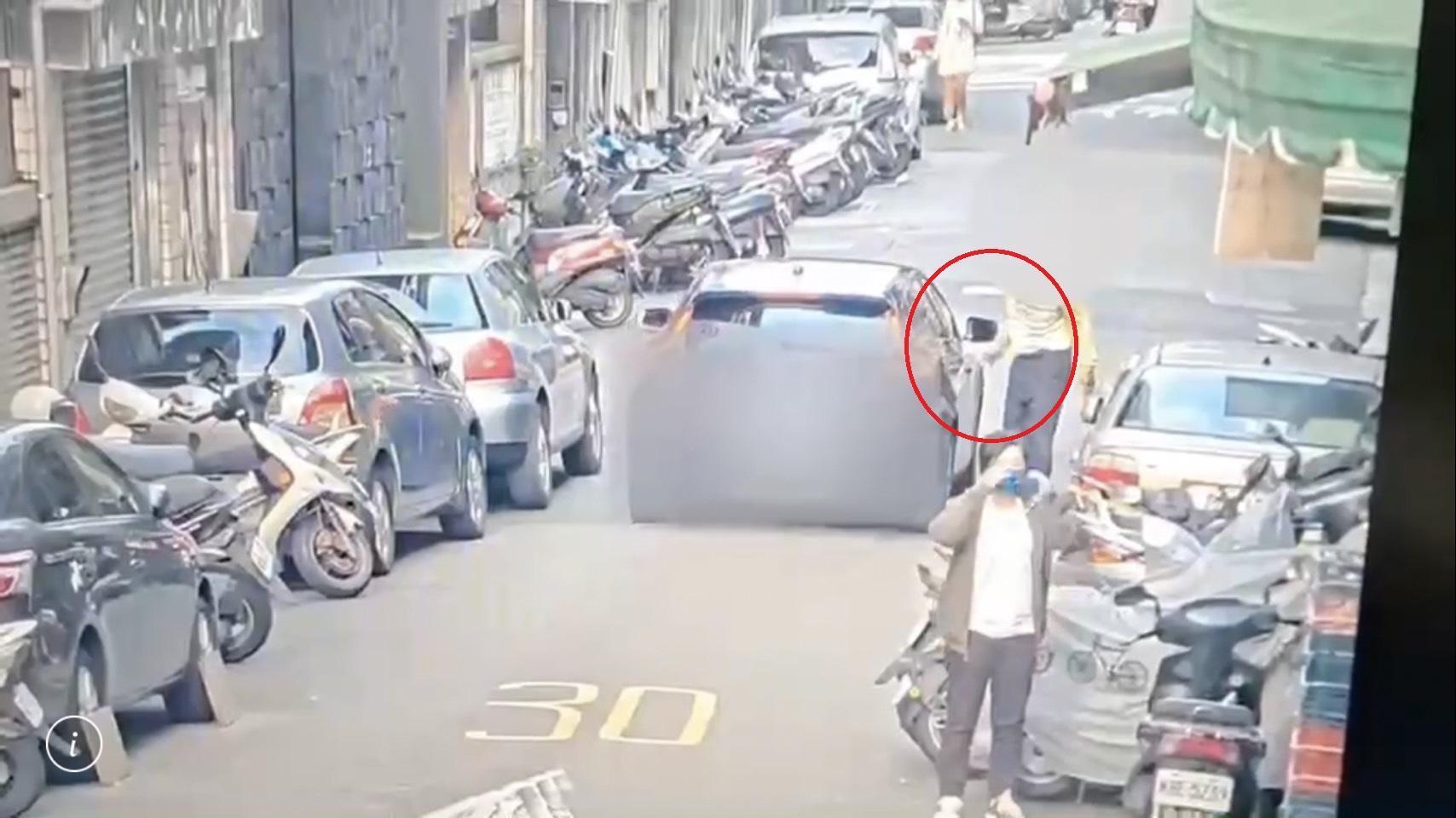 郭男（紅圈）刻意伸手碰撞駕駛車輛，趁機詐財。（翻攝畫面）