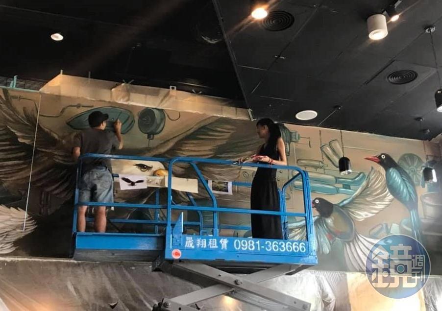 她帶一名助手上堆高自走車,幫印地安美式重機畫壁畫。