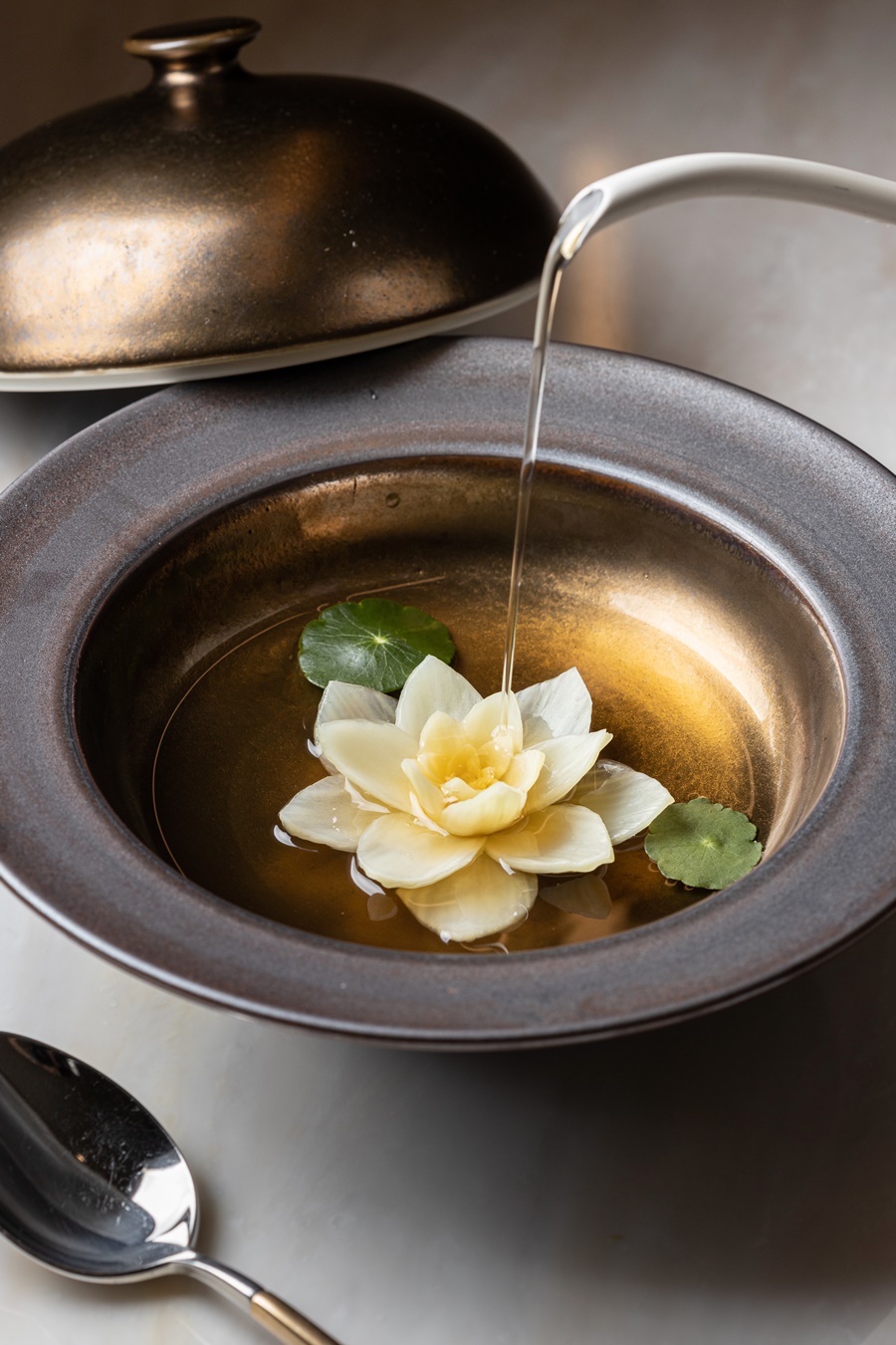 「蓮花」的蔬菜澄清湯，清甜秀麗，熬製高湯的食材會隨季節變換，呈盤如池塘。