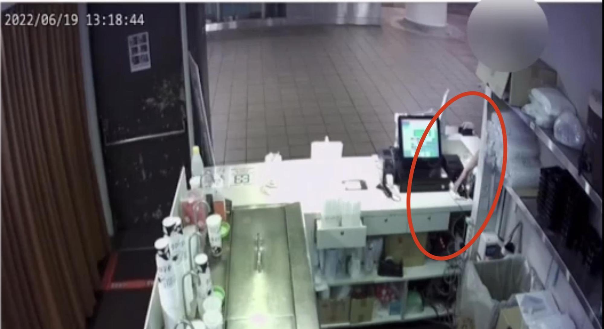 董男刻意走到店側面,突伸手偷走櫃台手機。(翻攝畫面)