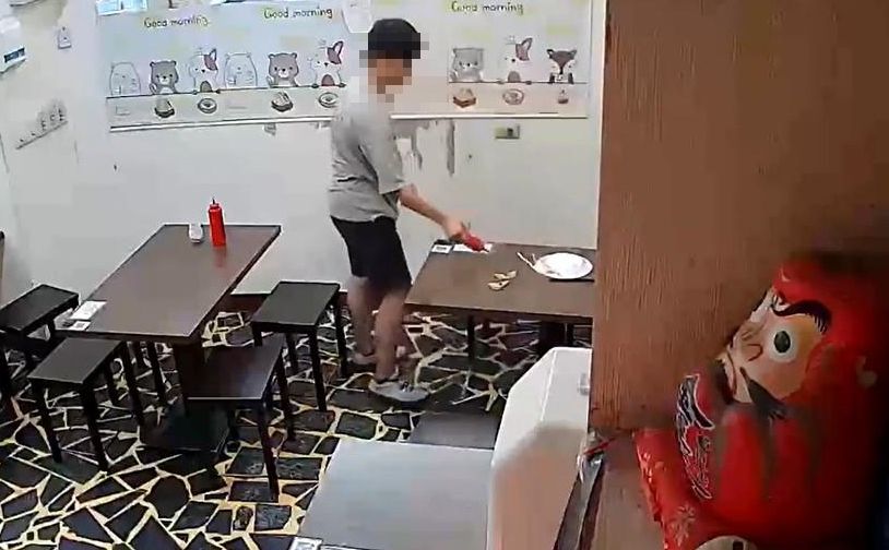 男子拿起辣椒醬開始在桌上「亂射」，導致店面髒亂不已。（翻攝爆料公社）