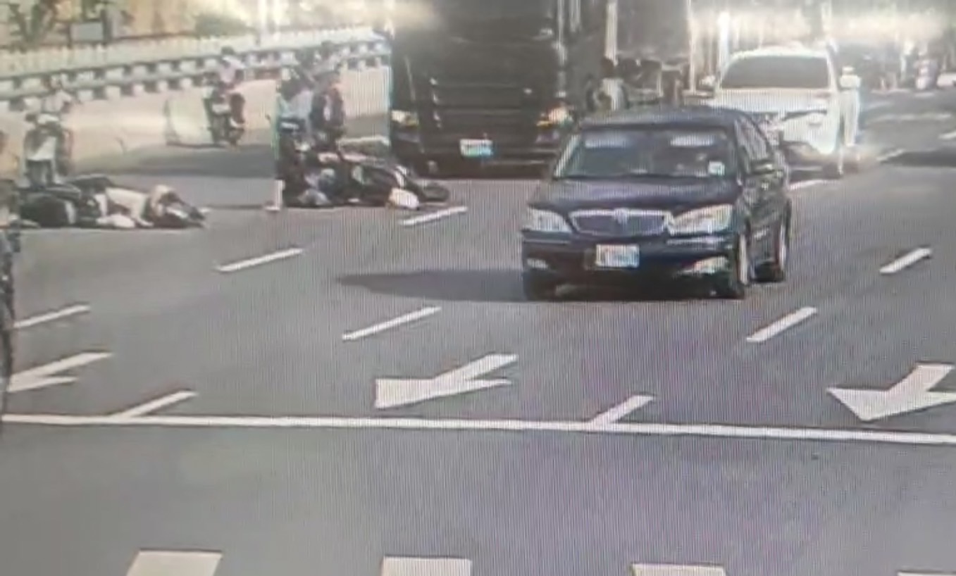 2車追撞倒地後，幸好後方大型貨櫃車緊急煞車未釀更大傷害。（翻攝畫面）