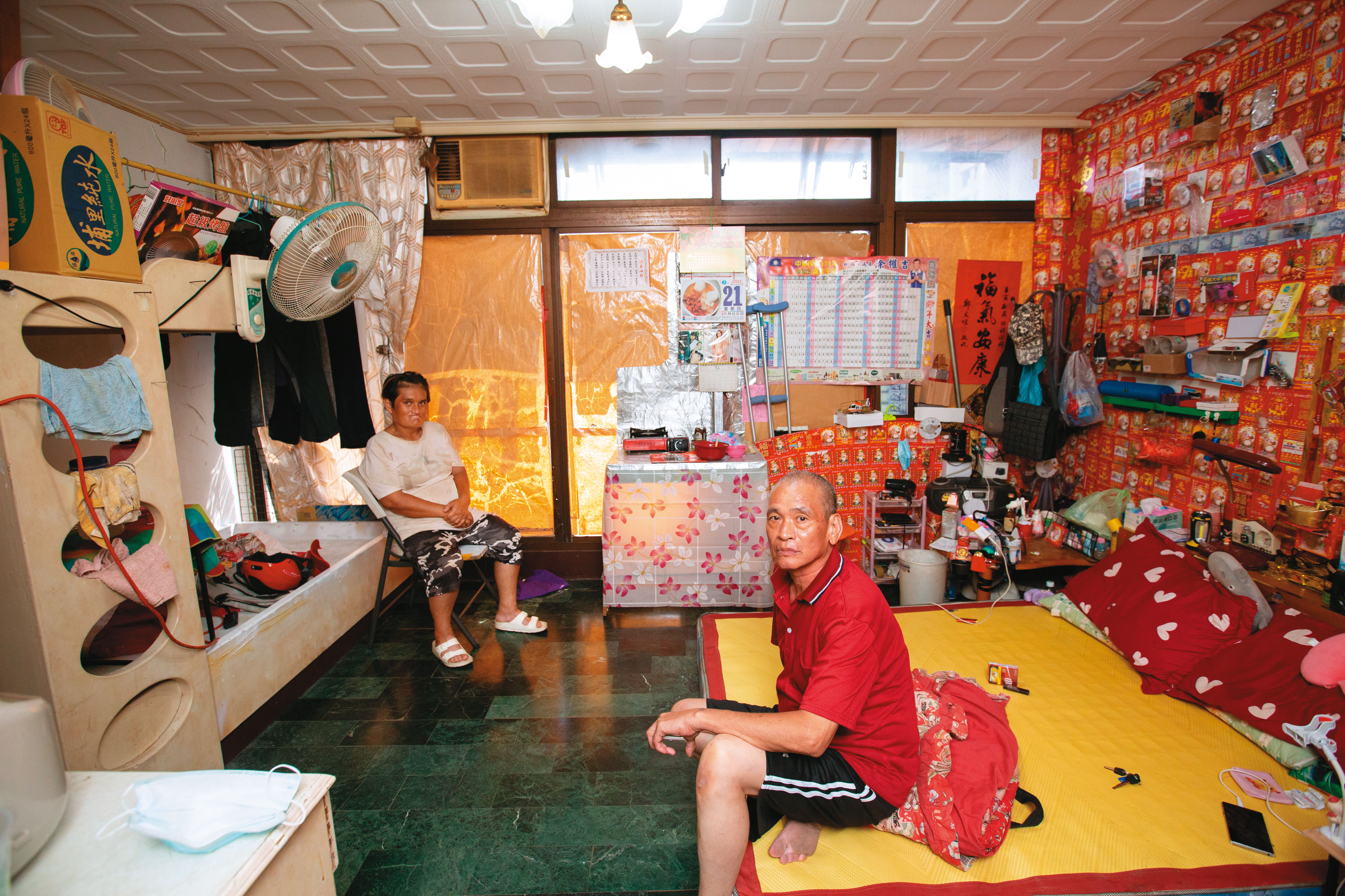 小淑（左）現在和男友（右）同住，牆上滿是沒有中獎的彩券。