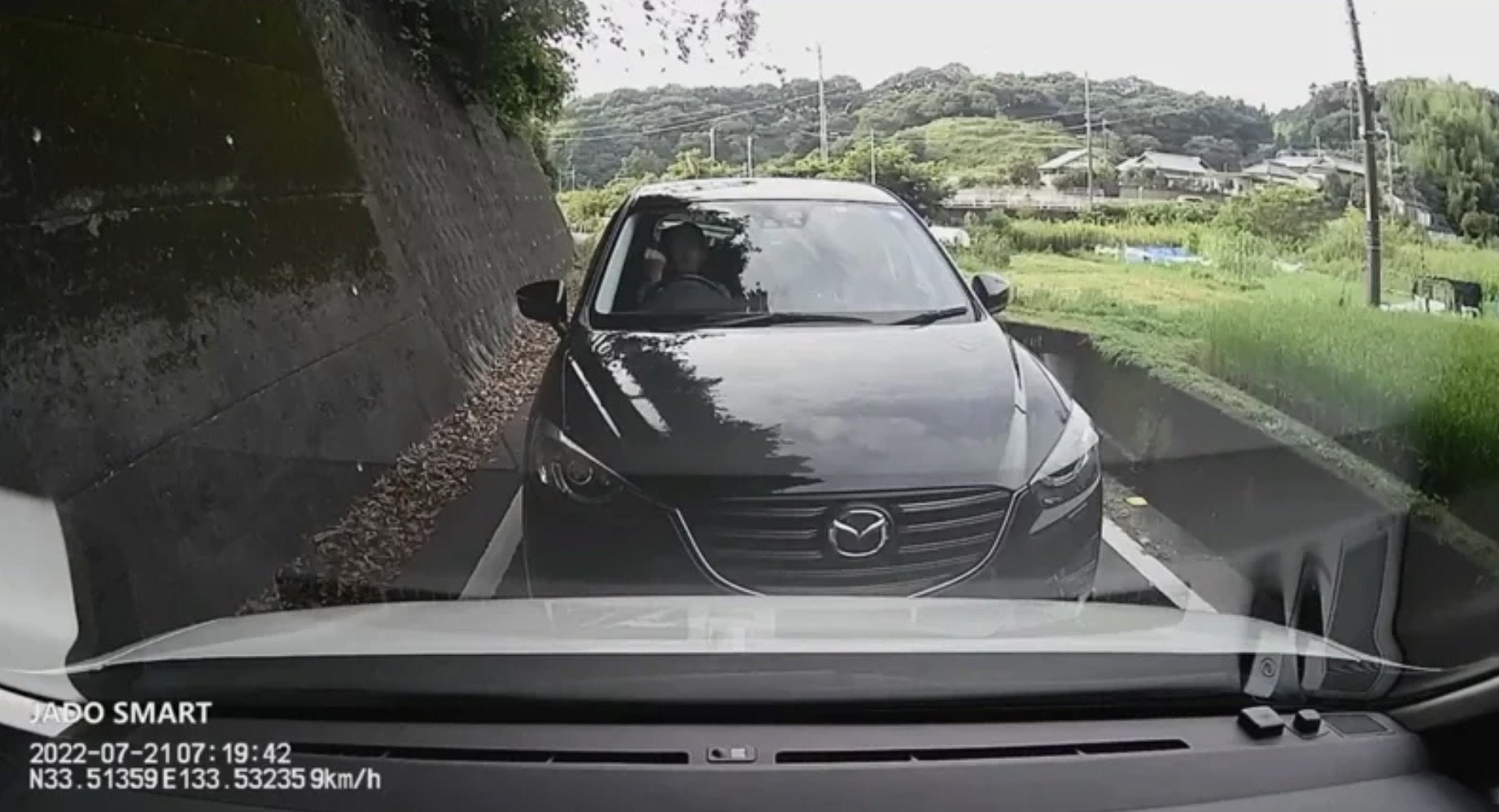日本網友分享一段行車紀錄畫面,只見兩台車行經狹窄道路,利用「猜拳」來決定誰該讓路。(翻攝推特@YamaMoto3700)
