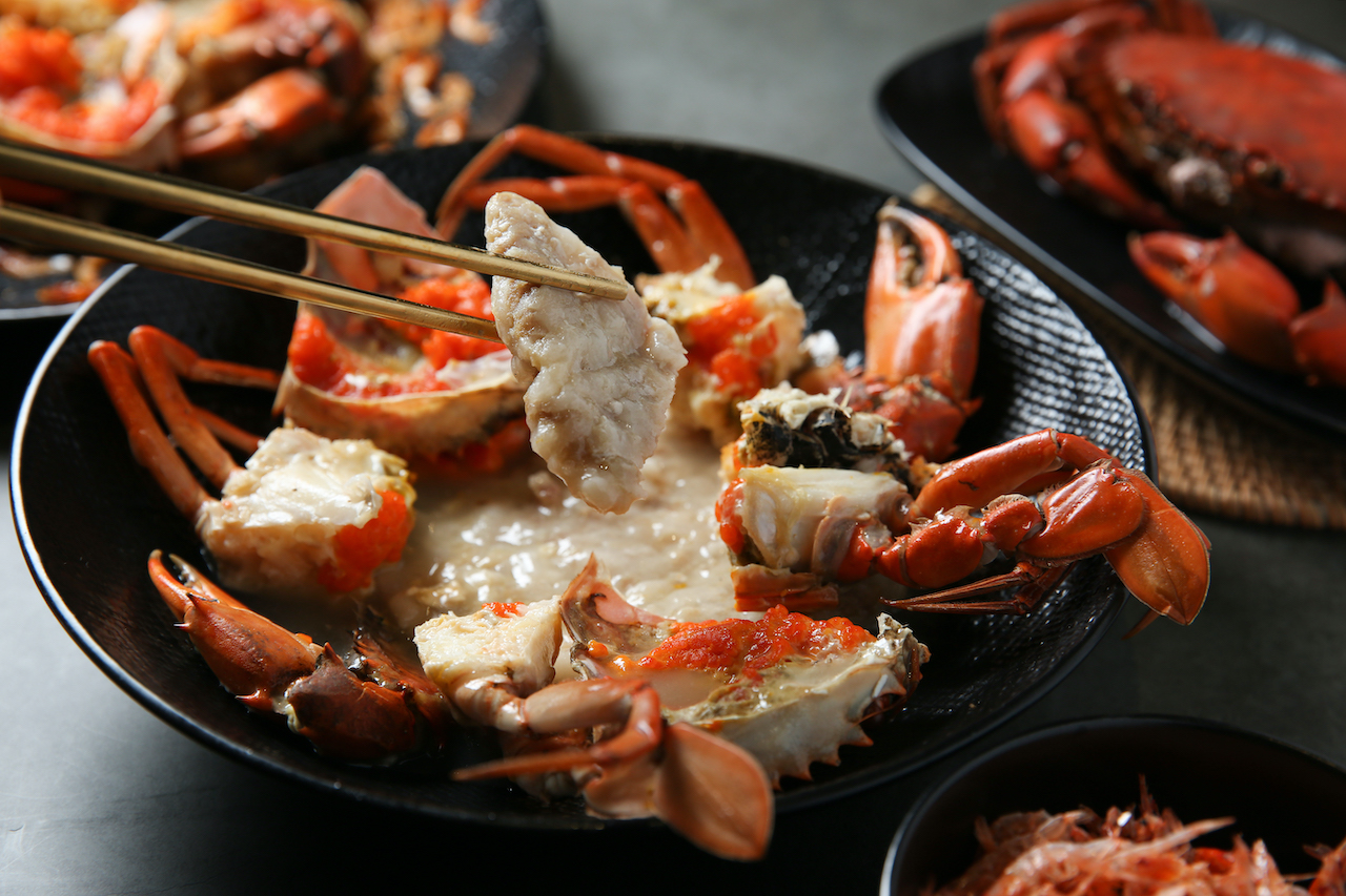 滑潤的「紅蟳蒸肉餅」（前，880元／份）豪邁地擺上整隻紅蟳；「A SHA紅蟳櫻花蝦米糕」（左後，限量，1,080元／份）蟹黃飽滿，米飯Q糯，鮮味層疊。