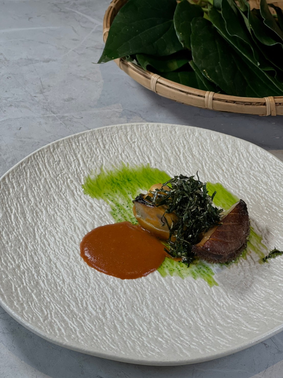 集結海陸食材的「貽貝／南非鮑魚／xo醬／胡椒葉／蒼蠅頭」撒上酥脆的荖葉絲，口感豐富。
