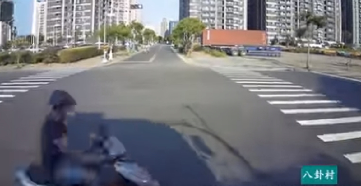 一名機車騎士闖紅燈，正好經過正常行駛的大貨車前，讓大貨車駕駛傻眼。（翻攝自八卦村行車紀錄器影片上傳中心臉書）