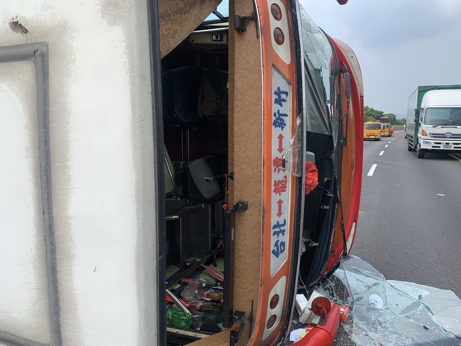 肇事客運擦撞大貨車後翻覆路中。(翻攝畫面)