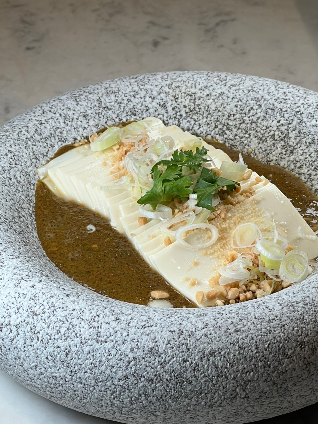 靈感來自皮蛋豆腐的涼菜「麻婆冷豆腐」，把皮蛋、自製辣椒醬打泥鋪在豆腐上，香麻微爽。（280元／份)