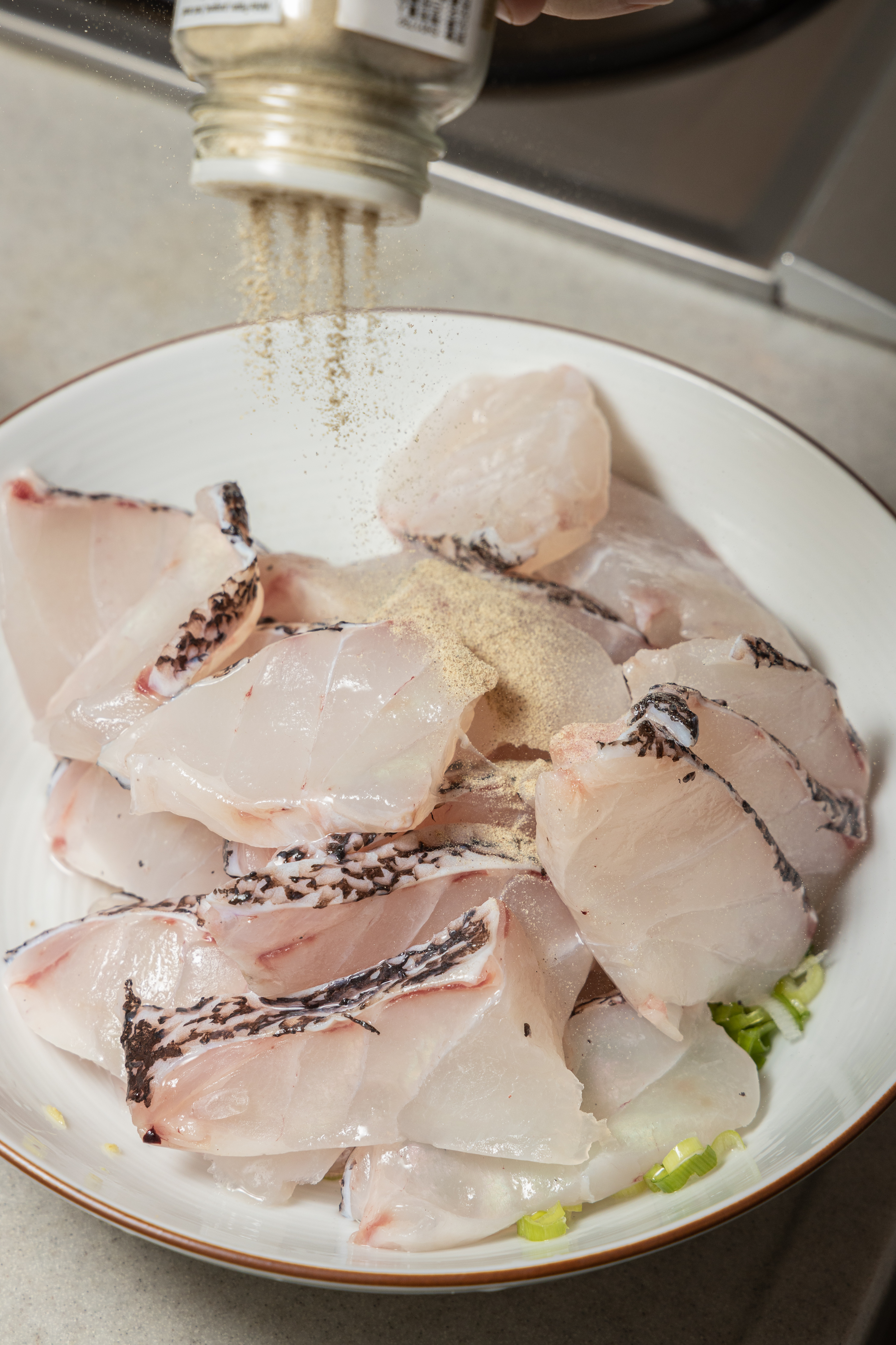 開始下蔥、薑、米酒、胡椒醃魚片。
