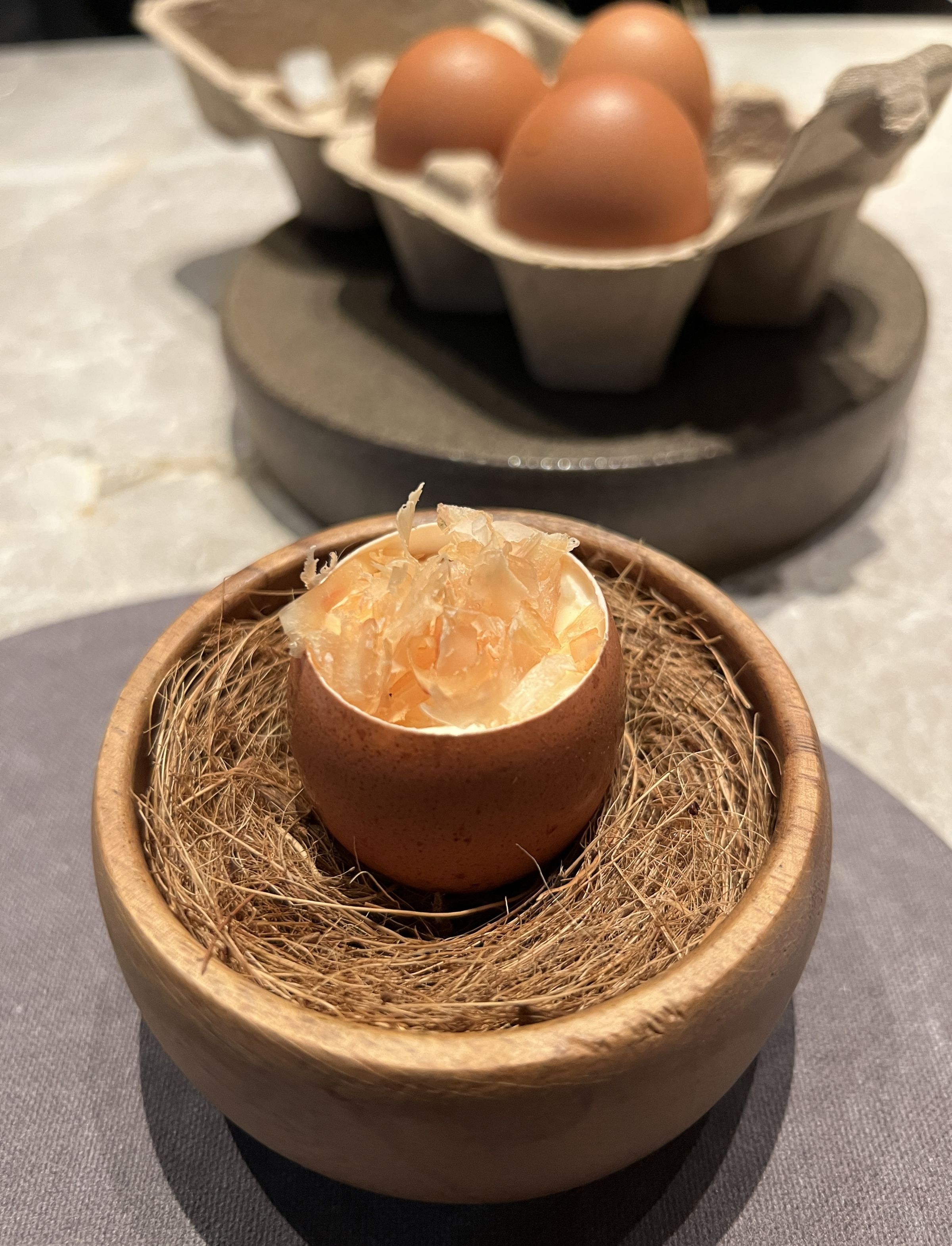 呼應「From egg to egg」概念，「雞湯茶碗蒸／瑞可達起司／雞柴魚／蕎麥粒／橙醋」以蛋殼為容器，自製雞柴魚粉撒在加入瑞可達起司的茶碗蒸上，賦予鮮味。
