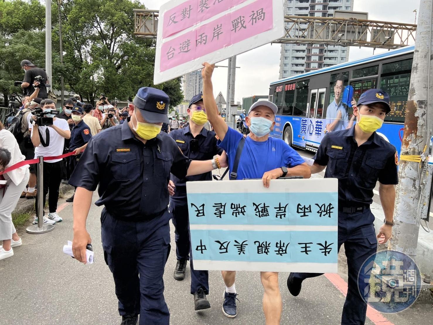 一名藍衣男子到現場抗議,遭警方帶走。
