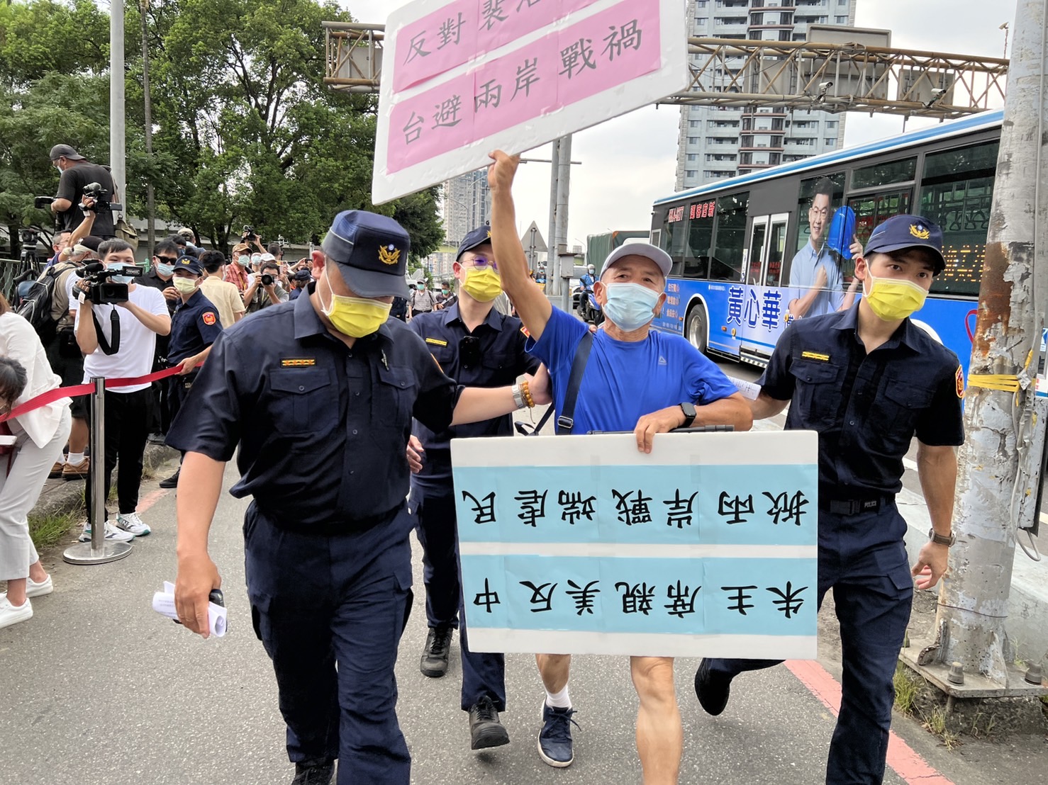 一名藍衣男子到現場抗議，遭警方帶走。