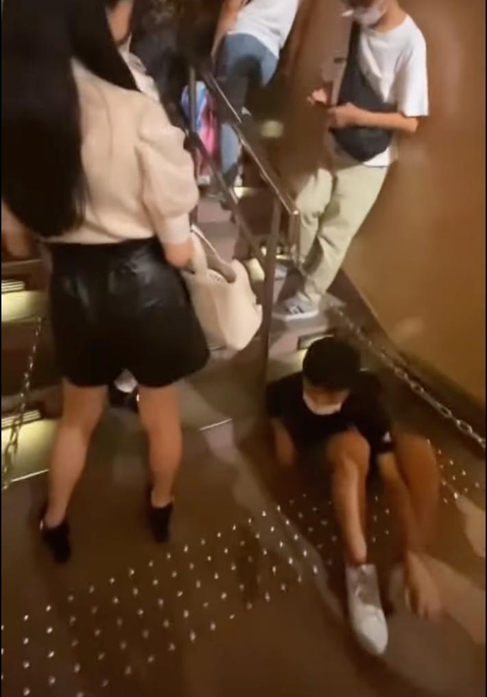 女遊客疑似察覺到少年的異樣,立刻閃向一邊,不過少年卻裝作若無其事趕緊把頭轉向別處! (翻攝自youtube)