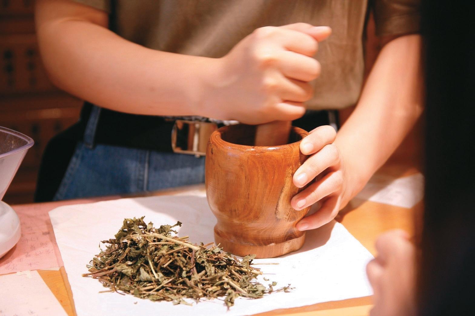 研磨中草藥材,以動手實作的方式加深大眾對中藥的認識。(簡敬恆提供)