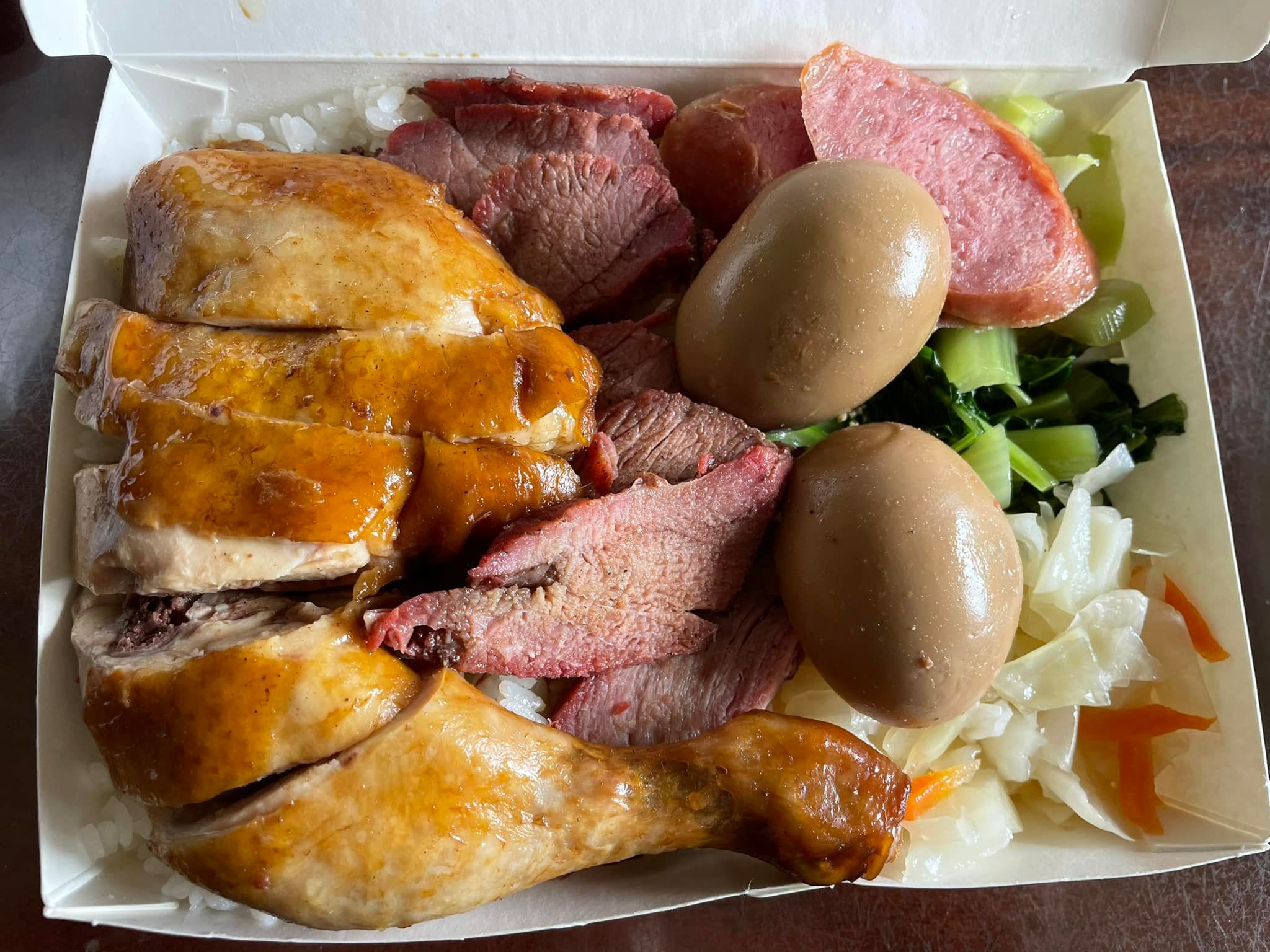 網友分享便當盒內有3樣菜，飯上面塞滿肉加上2顆滷蛋，還有一隻大雞腿，價格卻只要100元。（翻攝自爆廢公社）