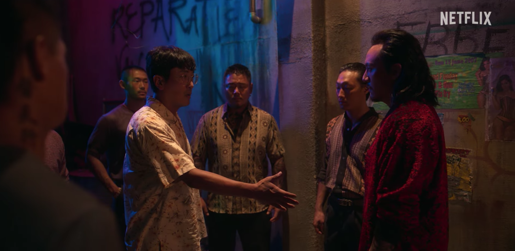 Netflix《毒梟聖徒》預告曝光,河正宇(左)對面這位穿大紅花襯衫的黑道大哥是張震,讓許多粉絲驚呼認不出來。(翻攝自Netflix Asia YT)