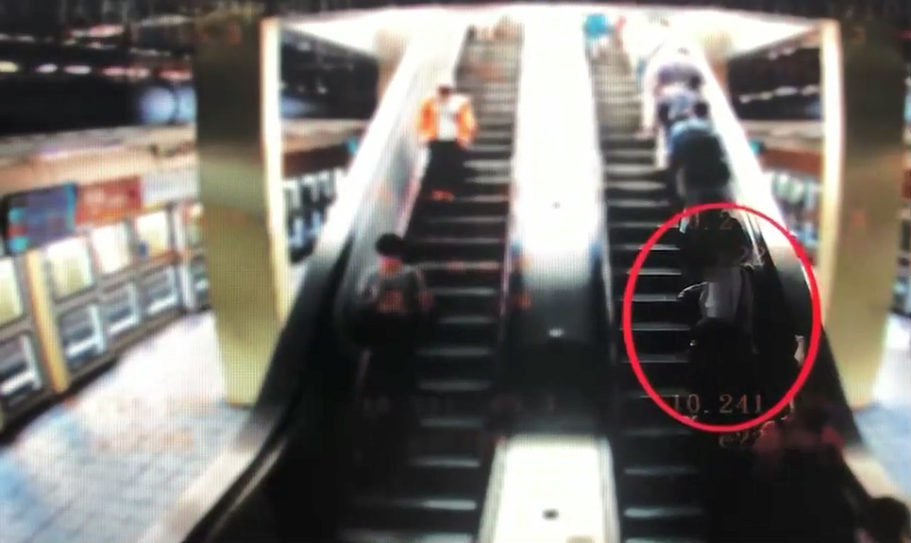 男子搭捷運文湖線，上電扶梯時調整彈匣露出，恐嚇經過民眾。（翻攝畫面）