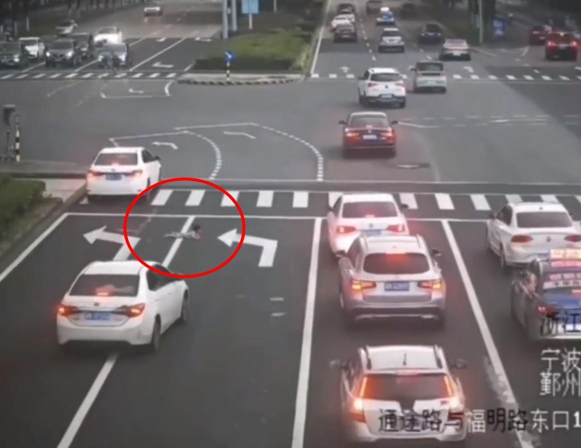中國一名粗心家長，竟讓小孩從後座掉出，現場險象環生。（翻攝自微博）
