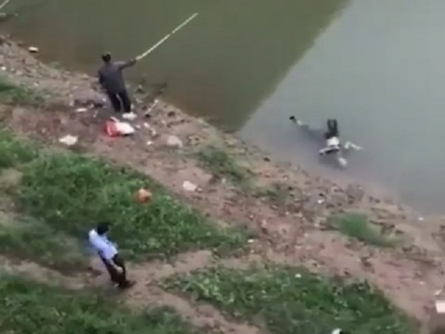 浮屍在水上漂，但民眾卻在同一條河川裡繼續釣魚的詭異畫面。（翻自推特）