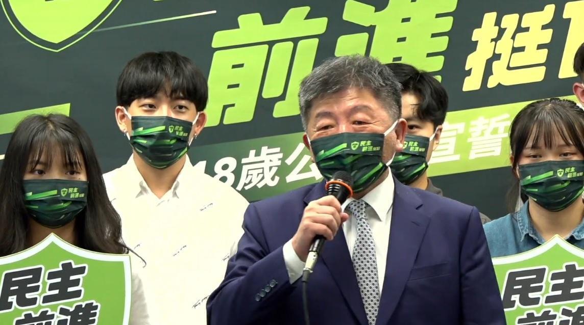 陳時中發言時，左後方的青年眼神灼熱。（翻攝民進黨臉書直播畫面）