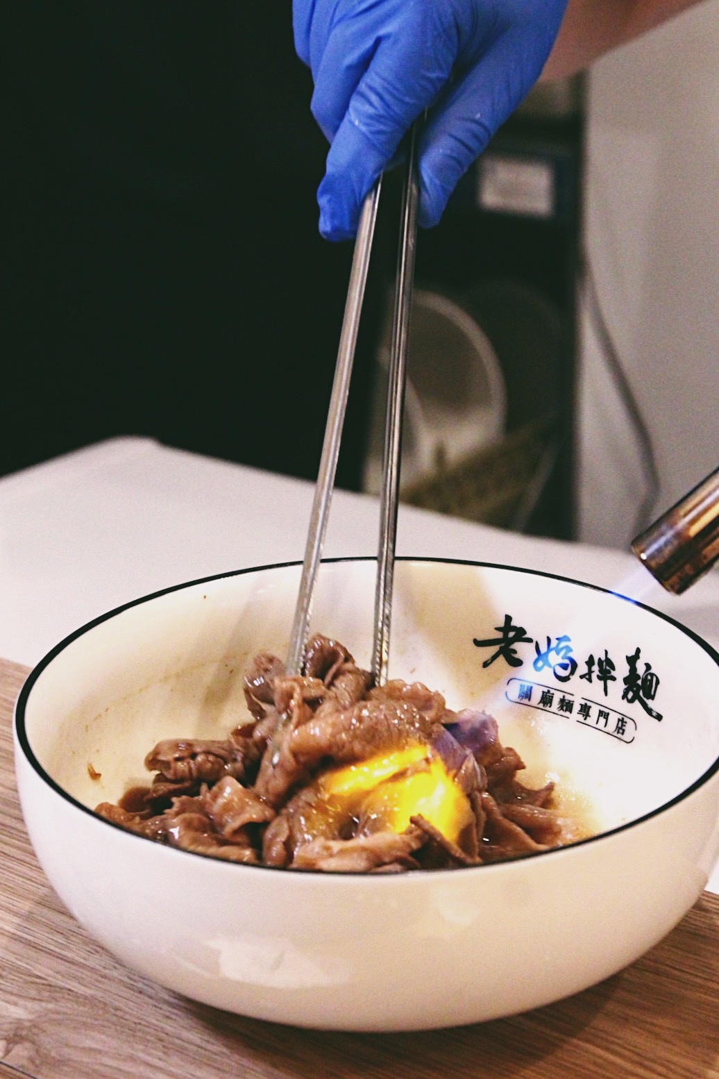 師傅不只拌麵，也在碗中拌肉炙燒，畫面令人垂涎。