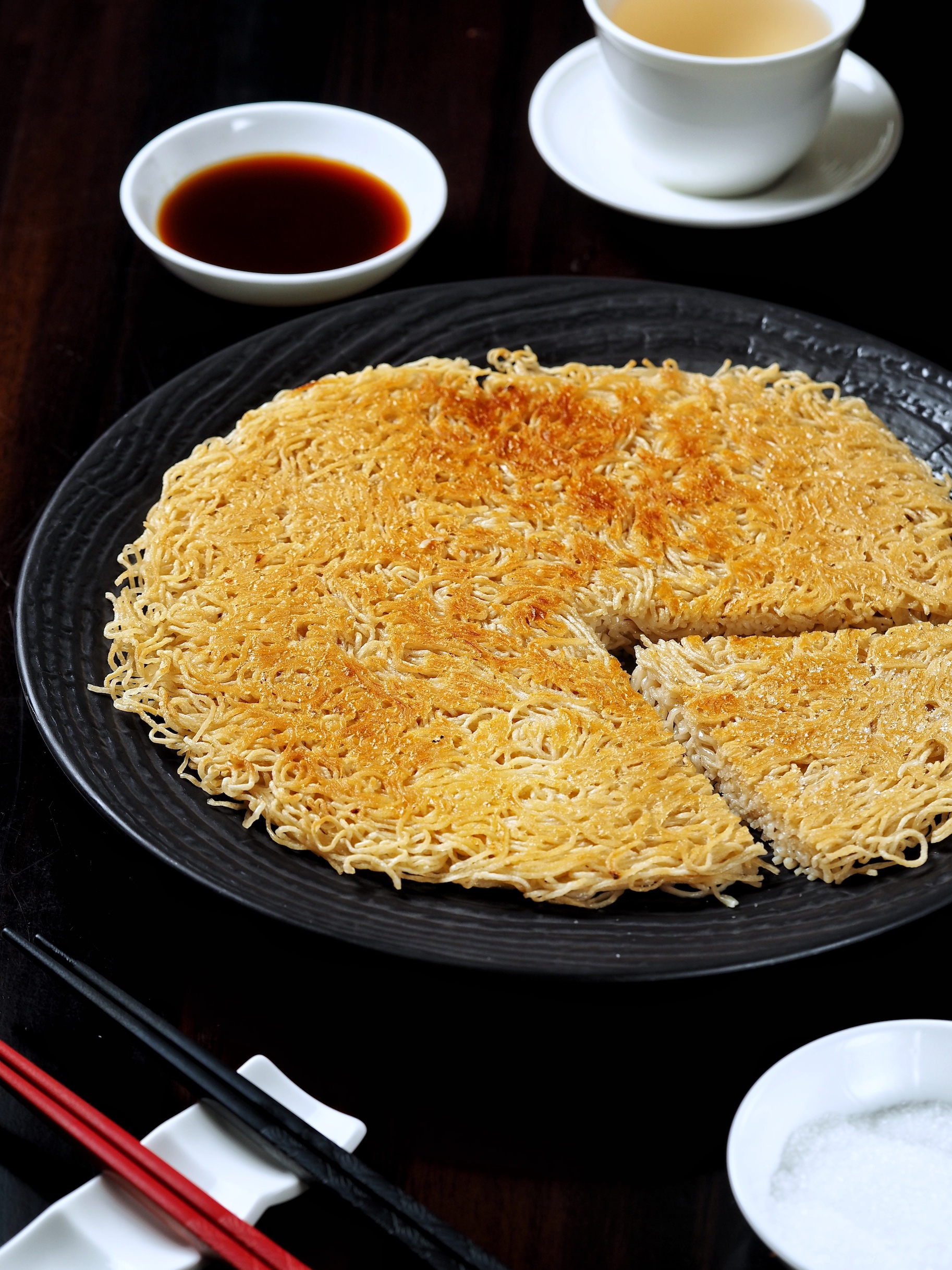 「湯種潮州煎伊麵」把自製鹼水麵做成Pac-man，麵條酥炸定型後不斷淋上高湯增鮮，蘸砂糖或特製黑醋吃都迷人。（380元／份）