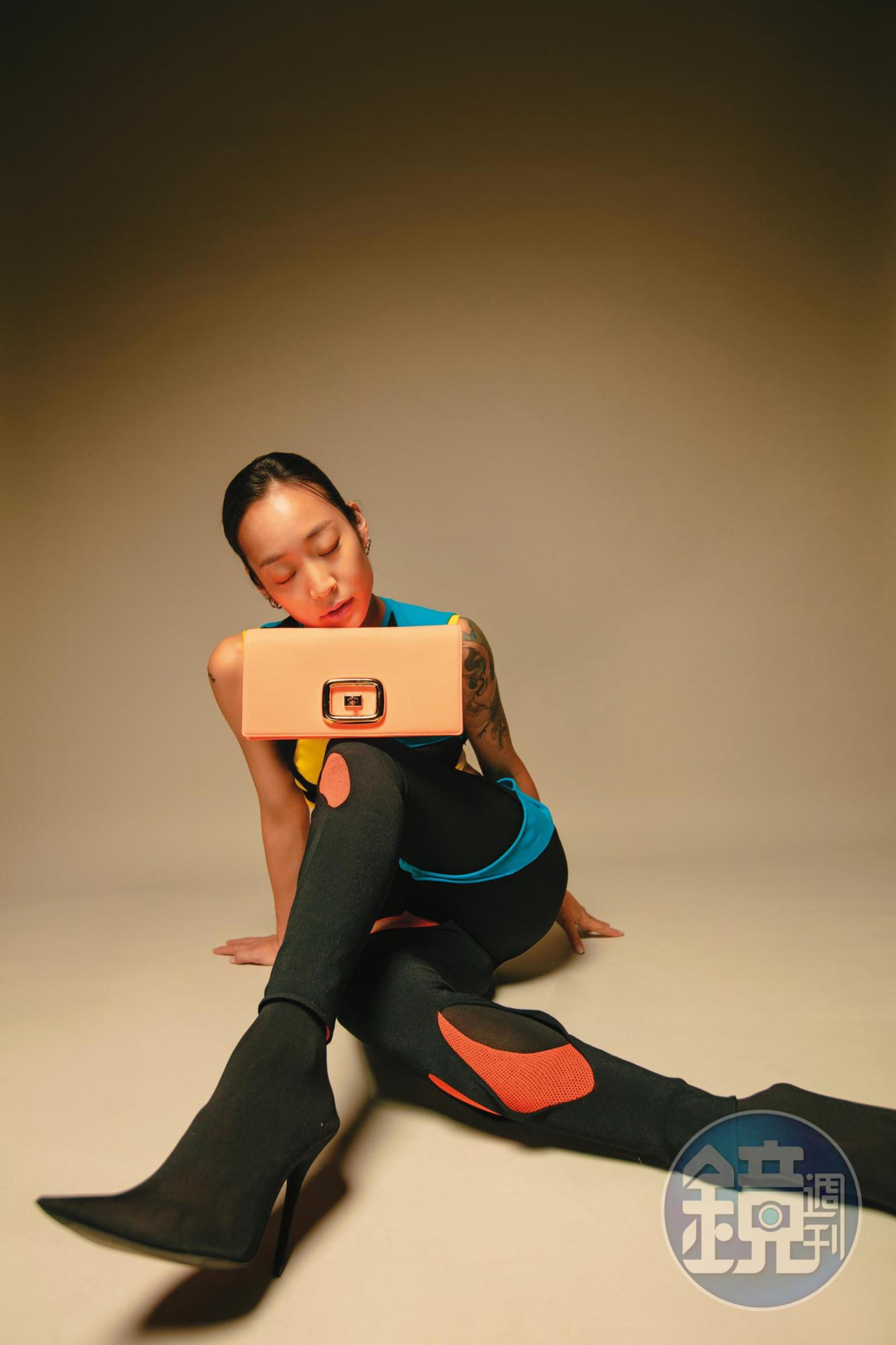 Viv Choc螢光方釦肩背包 NT$90,200 by Roger Vivier/撞色不規則剪裁上衣 NT$43,000 by LOEWE/撞色不規則剪裁leggings NT$43,000 by LOEWE/黑色尖頭襪靴 價格店洽 by BALENCIAGA