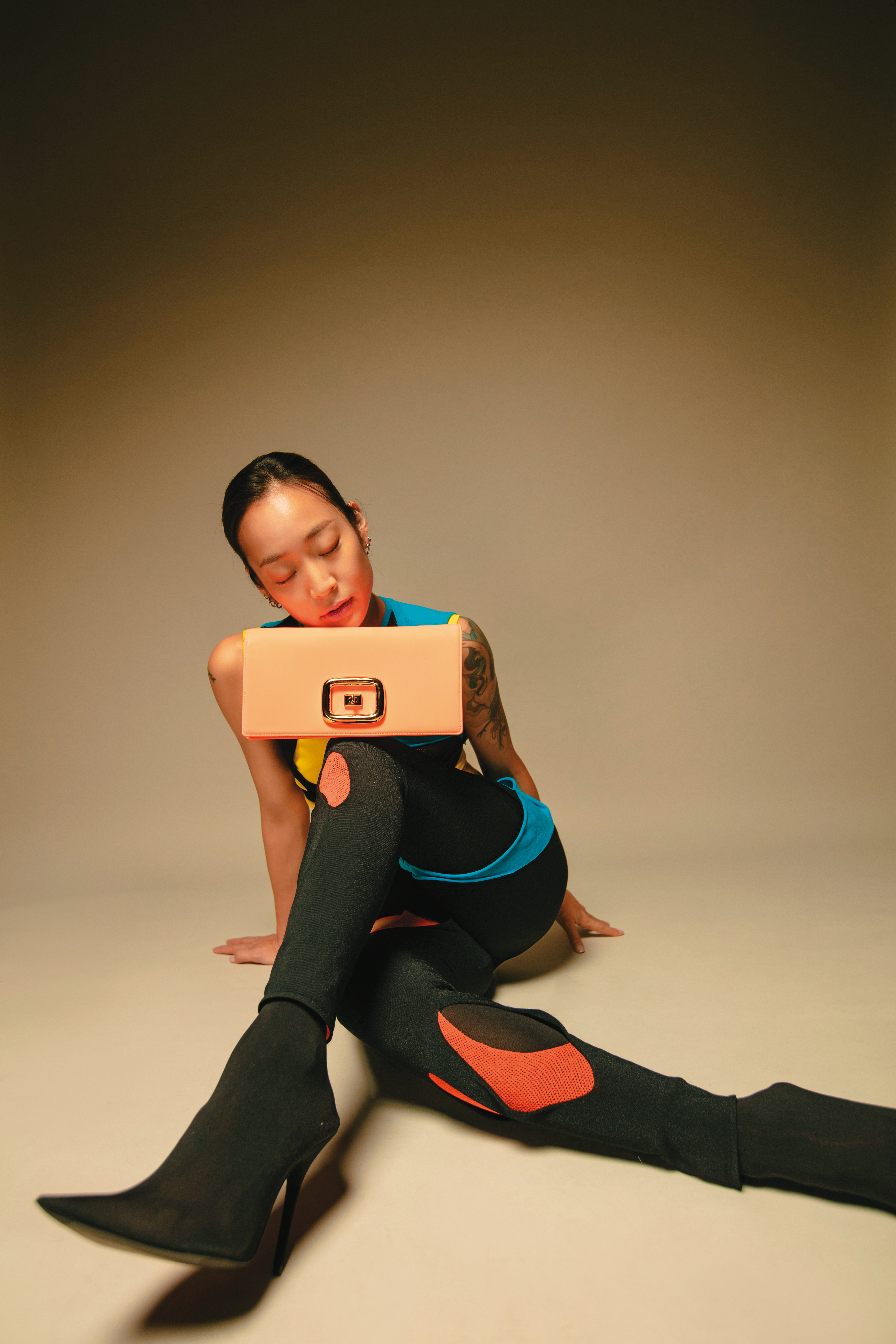 Viv Choc螢光方釦肩背包 NT$90,200 by Roger Vivier／撞色不規則剪裁上衣 NT$43,000 by LOEWE／撞色不規則剪裁leggings NT$43,000 by LOEWE／黑色尖頭襪靴 價格店洽 by BALENCIAGA