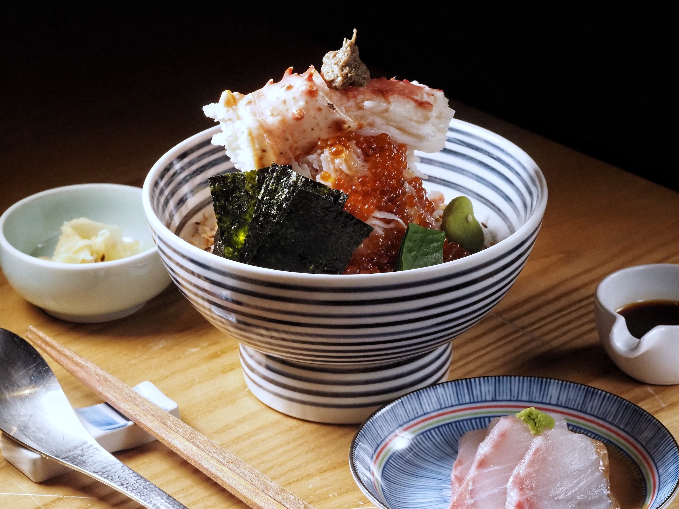 辻半的「珠寶盒海鮮丼 雪」以蟹膏和帝王蟹腿壓頂，海鮮團子拌入滿滿蟹肉，讓蟹控大滿足。（999元／份）