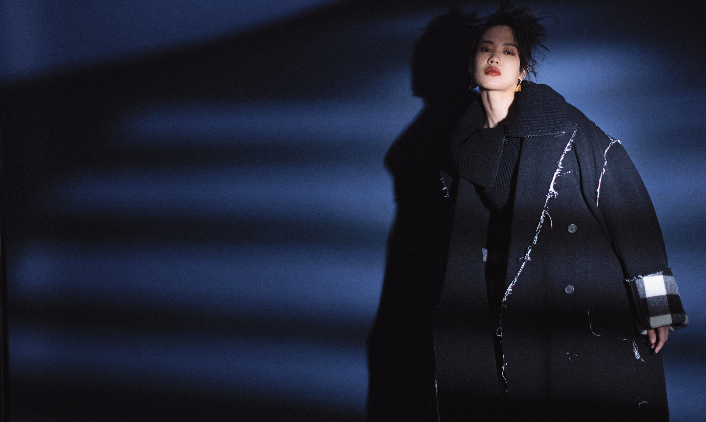 黑色造型大衣 NT$108,100 by BALENCIAGA；黑色針織洋裝 價格店洽 by TOD'S；三角形ONE LIFE摩斯密碼耳環 NT$7,900 by APM MONACO。