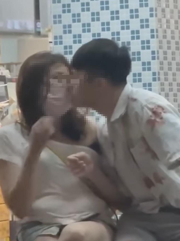 男子拉下女子口罩，忘情親吻。（翻攝爆廢公社）