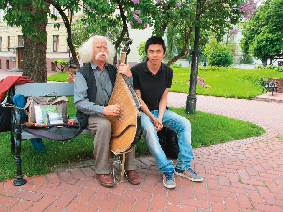 老爺爺史提潘(左)是徐裕軒(右)在烏克蘭的第一個好友,2人相識至今12年,仍然保有聯絡。圖為徐裕軒赴烏克蘭交換時,與彈奏班杜拉琴的史提潘合影。(徐裕軒提供)