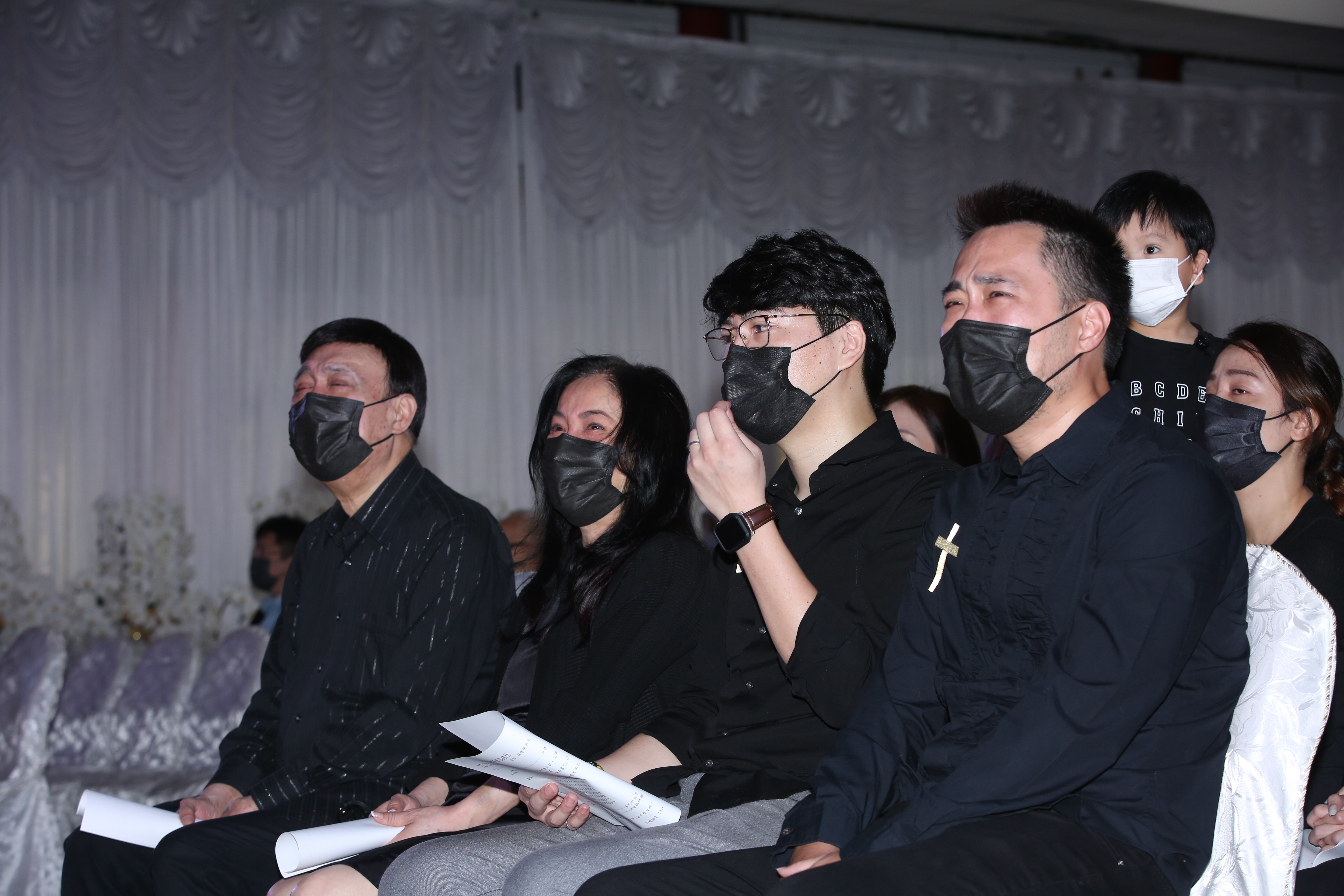 追思會上播放余苑綺的回憶影片，余家人在台下含淚觀看。