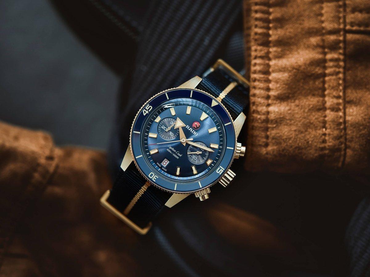 RADO Captain Cook Chronograph 此錶以43mm青銅材質錶殼，配以藍色太陽放射紋面盤，與藍色陶瓷材質錶圈嵌片。而且青銅材質鍍以23K金薄膜，使外觀色澤接近玫瑰金，也延緩了變色速度。盒形藍寶石水晶鏡面採用雙面防反光鍍膜處理，擁有美好的復古質感。搭載R801機械計時機芯，提供59小時動力儲存，並進行5方位調校，擁有更高的精準度。定價約NT$136,100