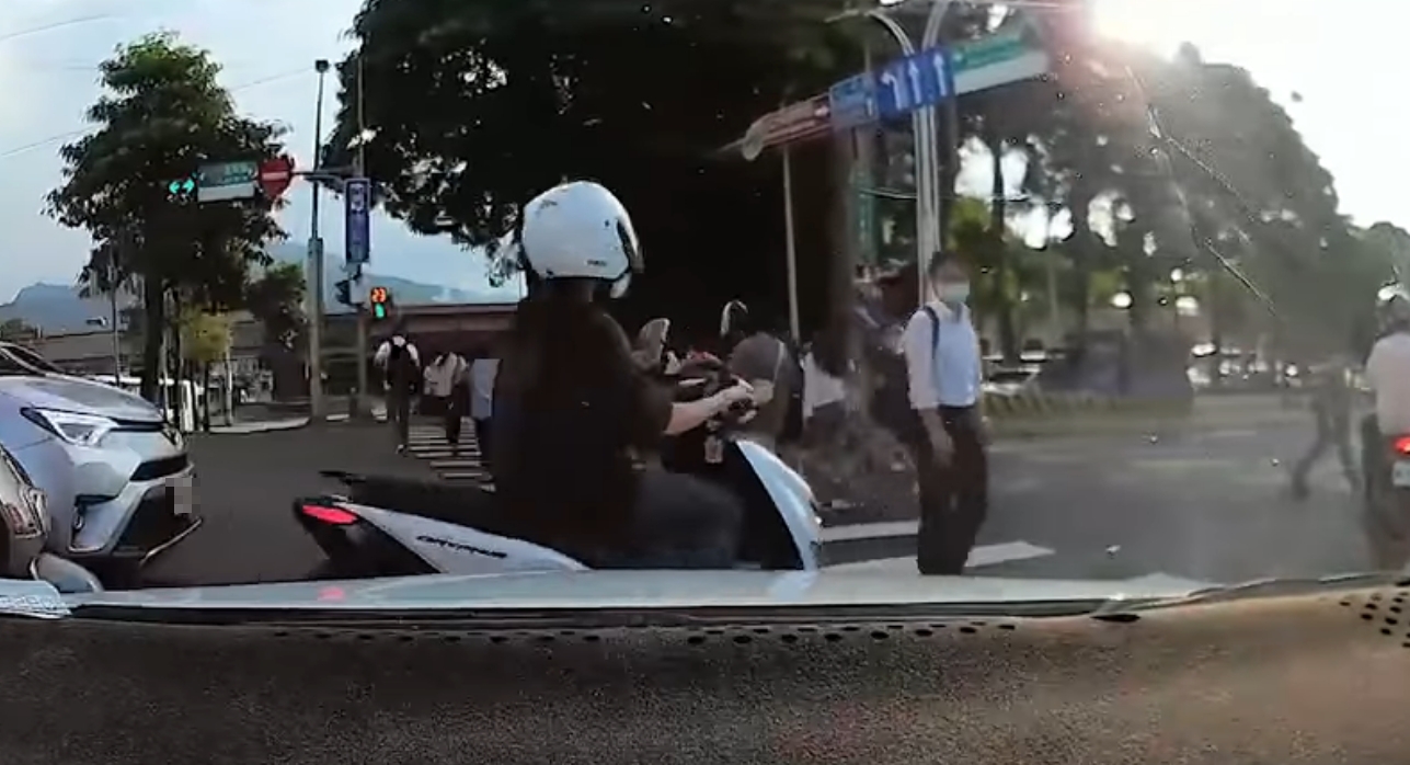 網友分享一行車紀錄器影片，一名機車騎士無視行人綠燈，硬闖想通過，結果被路人一掌擊落。（翻攝自爆廢公社）
