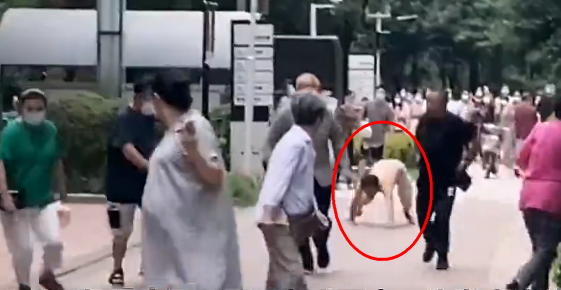 男子半裸當街爬行撲咬路人，嘴巴發出逼真狗叫聲。（翻攝網易視頻）