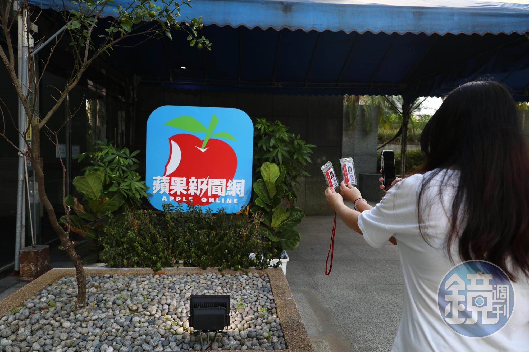 《蘋果新聞網》員工拿識別證和logo合影留念。