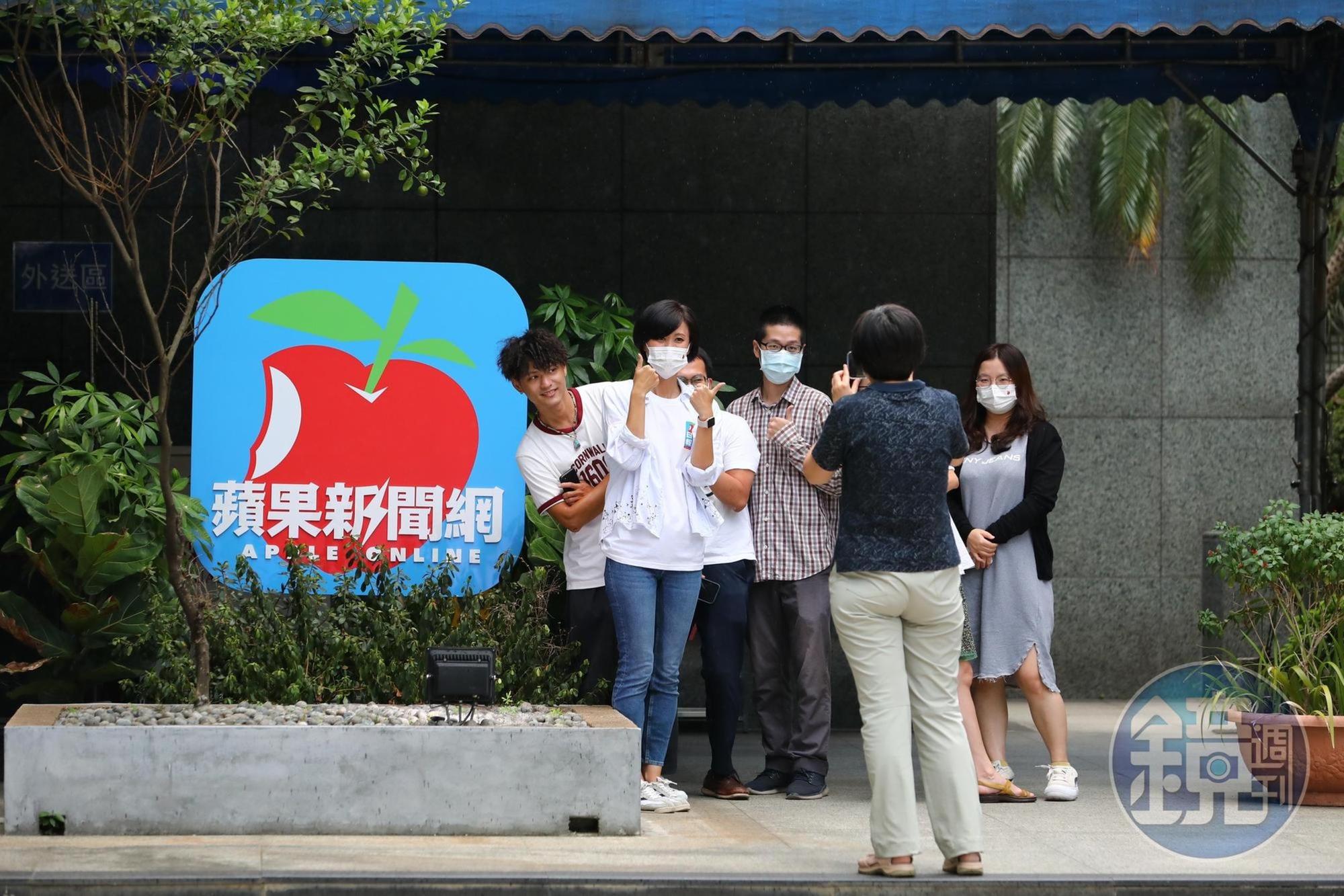 《蘋果新聞網》員工搶著與蘋果logo合照。