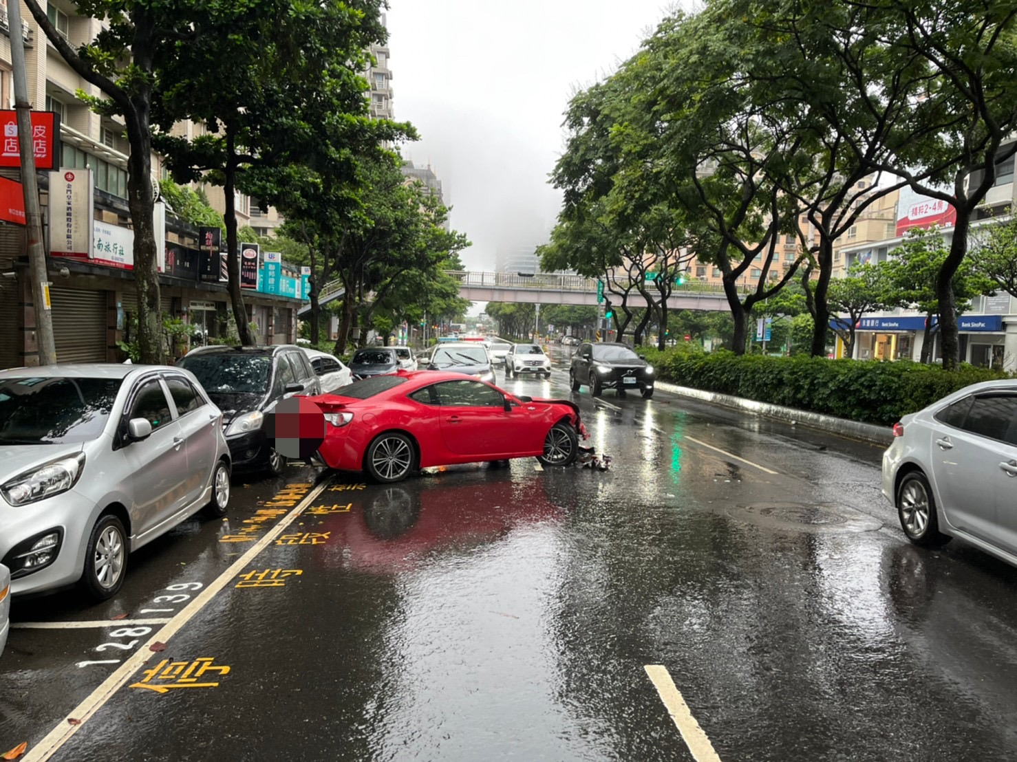 紅 色自小客車天雨路滑,衝撞停在停車格內小轎車。(警方提供)