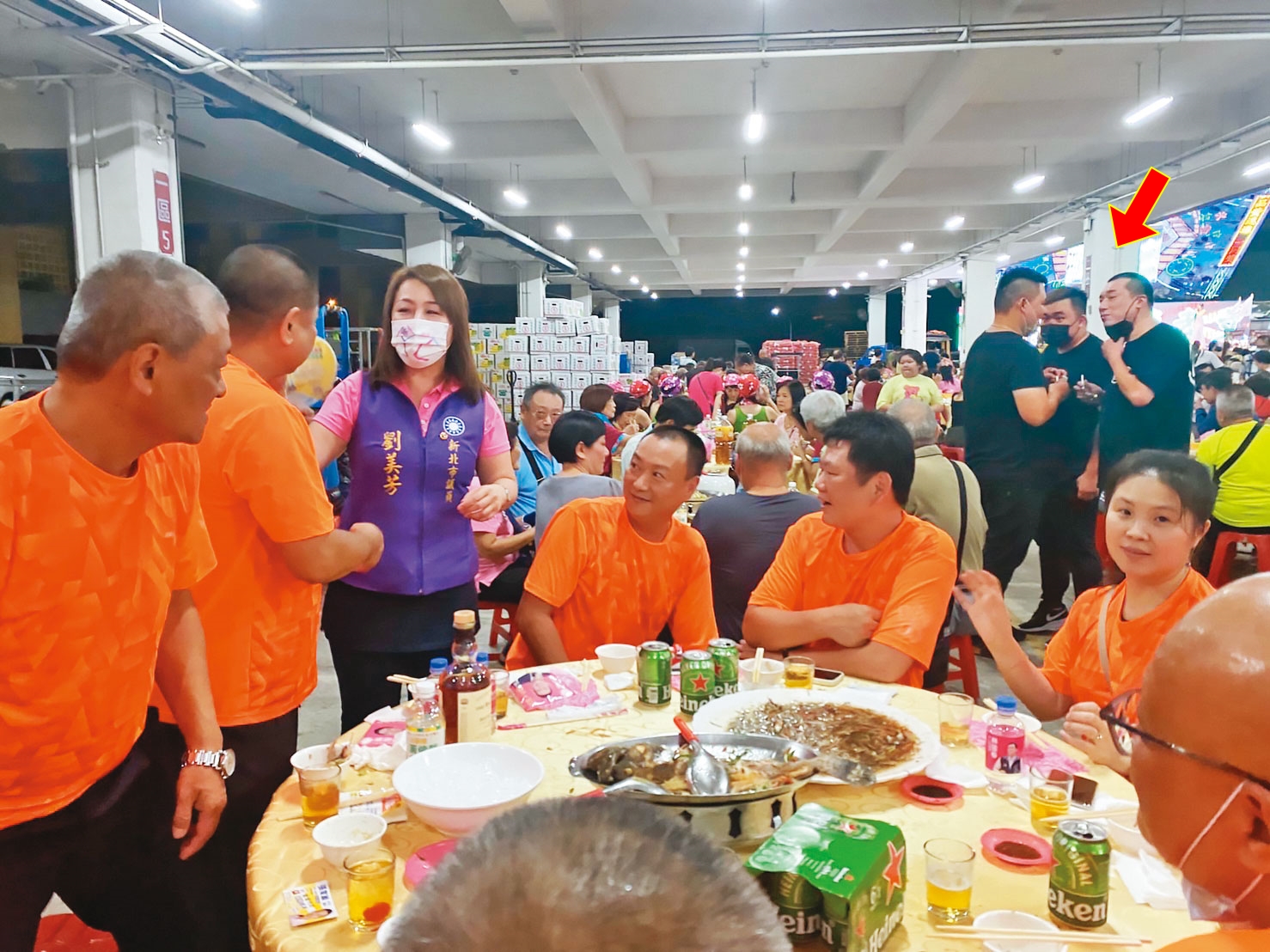 劉美芳在餐會上逐桌拜票，沒想到3名黑衣人（箭頭處）竟一路尾隨盯梢。（讀者提供）