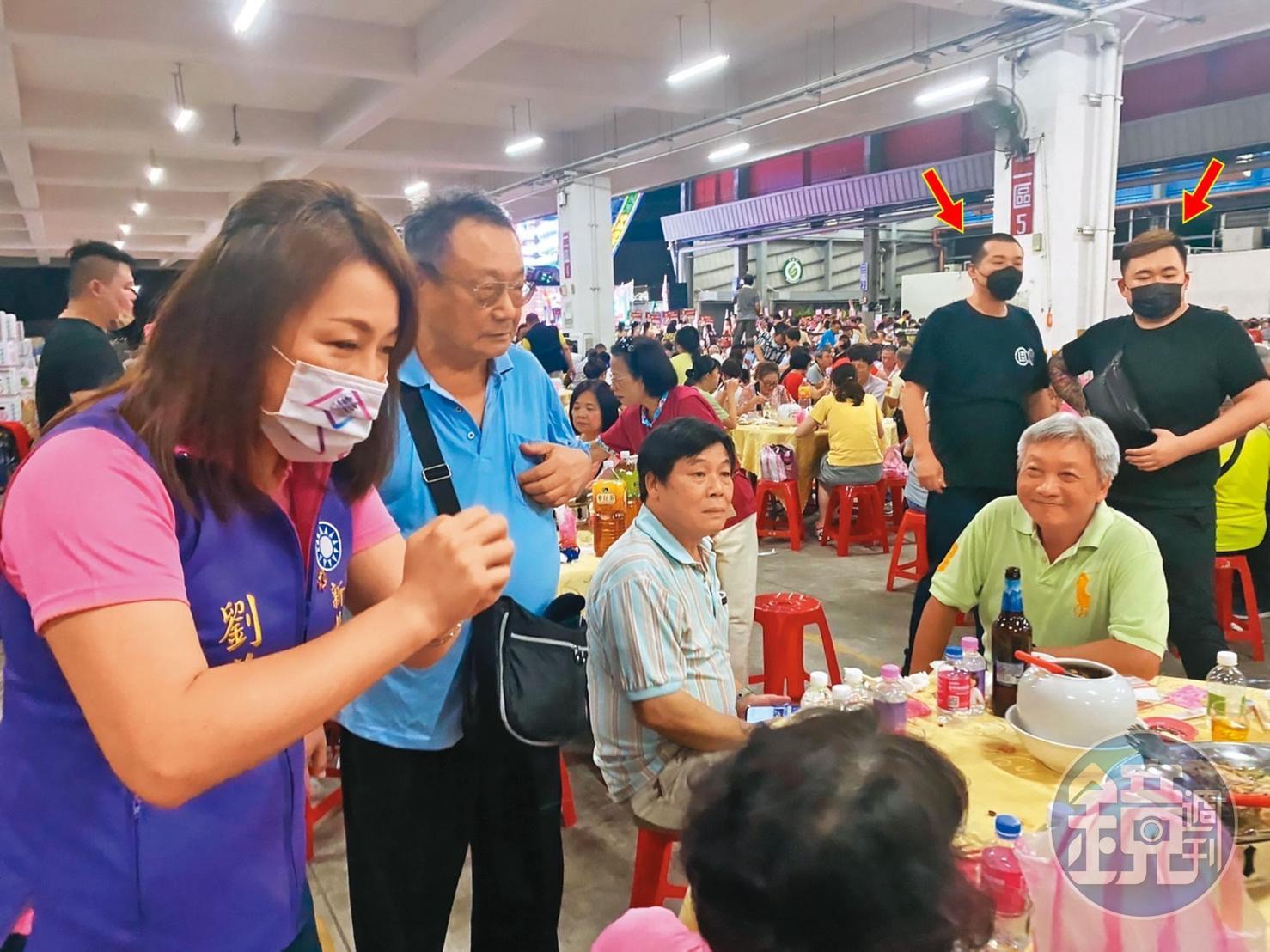 新北市議員劉美芳到餐會拜票時,遭多名黑衣人(箭頭處)跟蹤尾隨。(讀者提供)