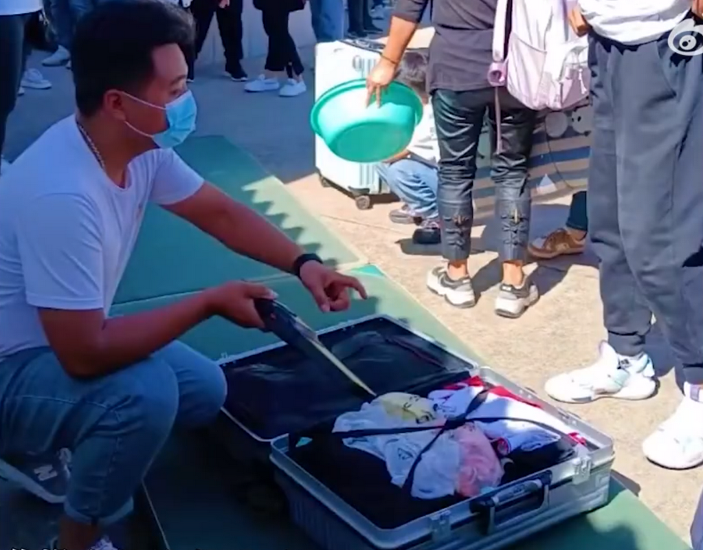 校方人士檢查學生行李,避免學生偷夾帶手機。(翻攝《巨浪視頻》)