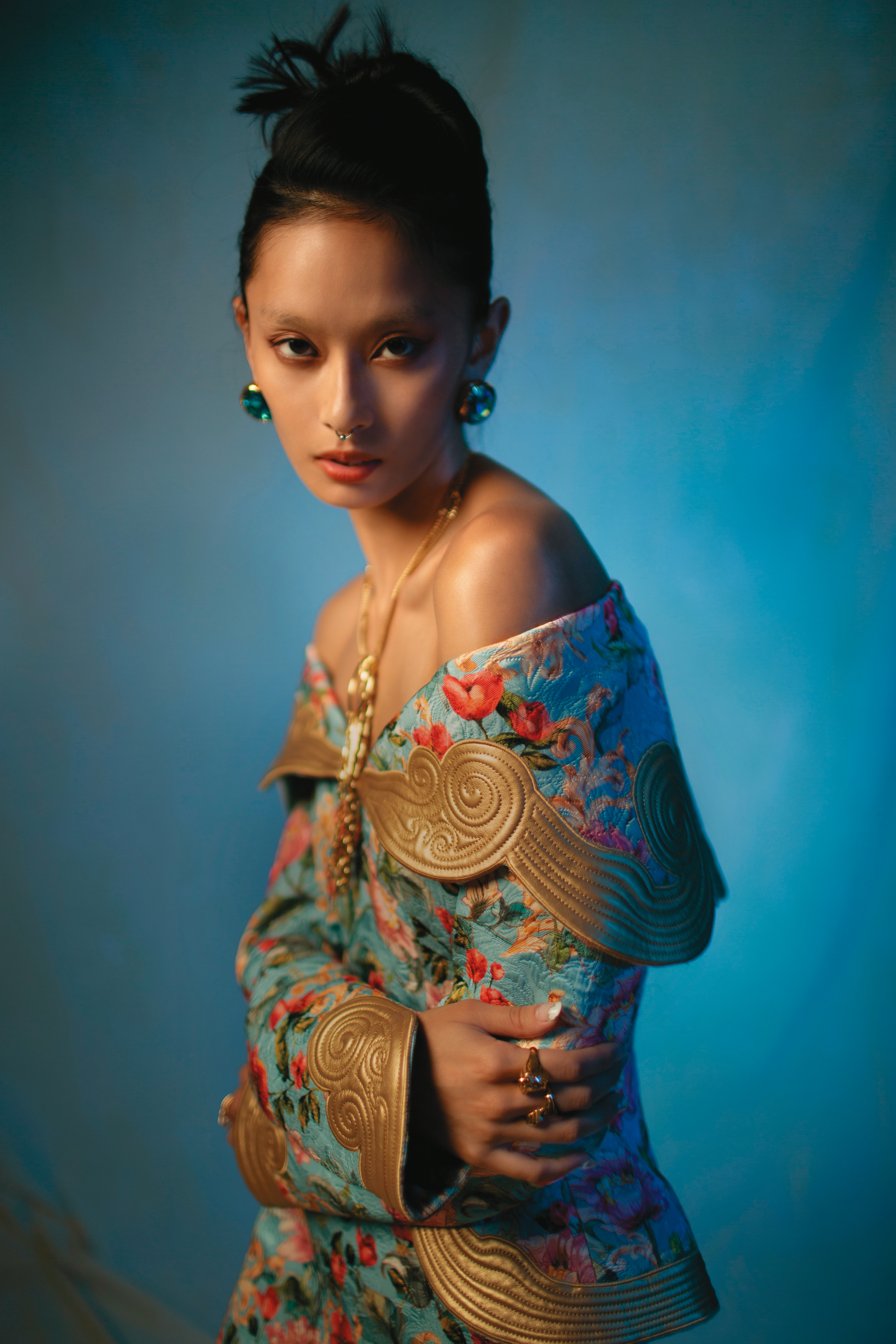碎花洋裝NT$244,300 by MOSCHINO；藍色水晶耳環 價格店洽by VERSACE；不對稱裝飾設計眼鏡鍊作為項鍊NT$8,310 by GENTLE MONSTER；La Medusa戒指NT$13,000 by VERSACE；Medusa Greca環形戒指 價格店洽 by VERSACE。
