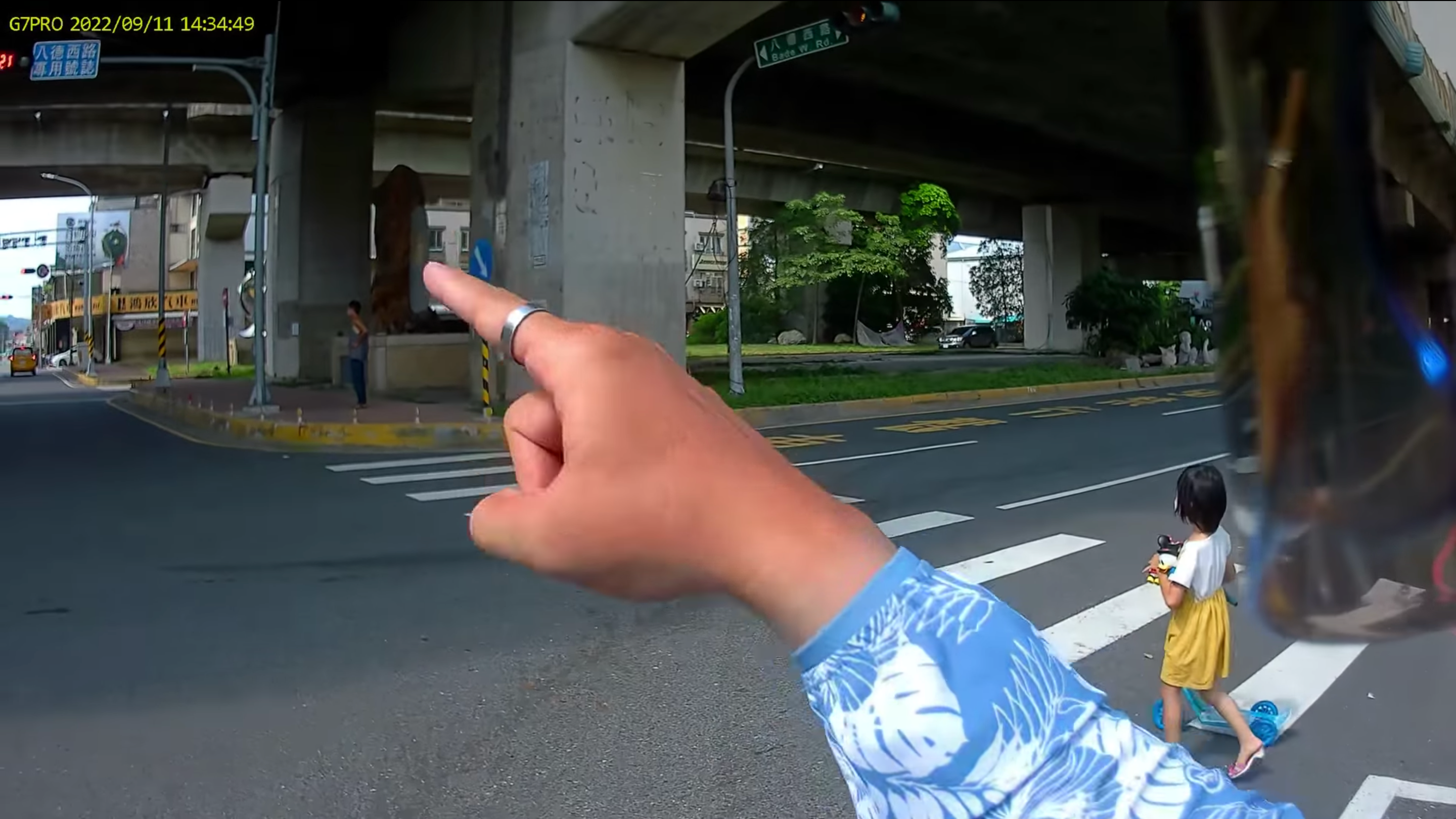 一名機車騎士在停等紅燈時看到欲闖紅燈的女童，趕緊出聲阻止她往前衝。（翻攝自爆料公社臉書）