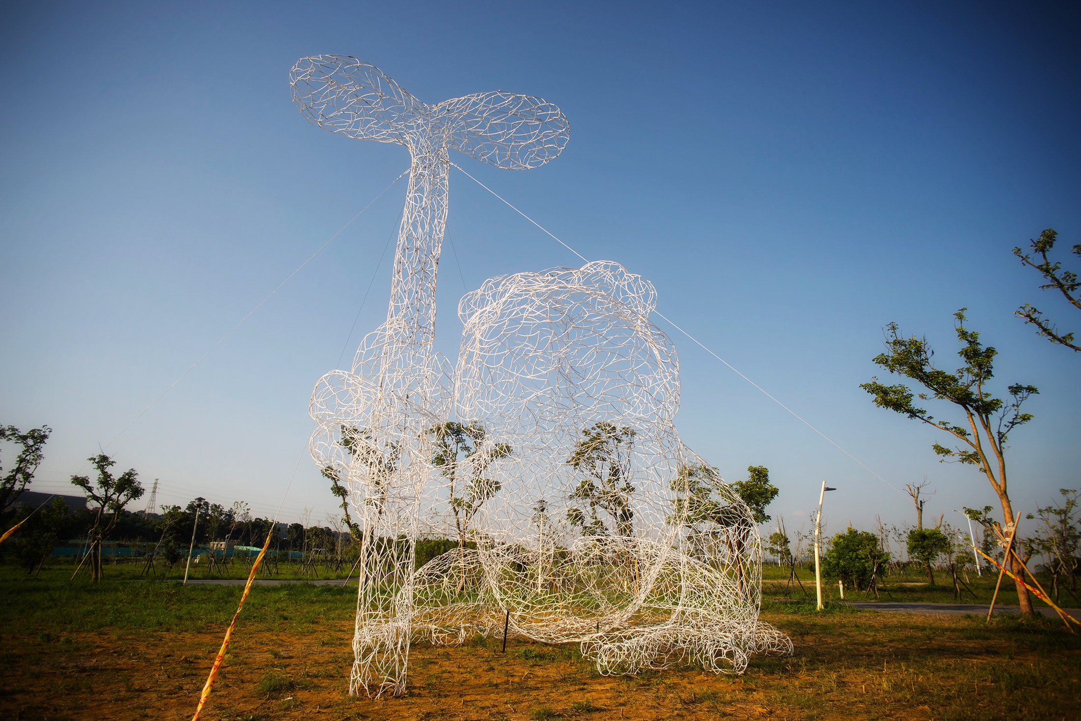 作品《蛙尬藝來做伙》以桃園的野生物種翡翠樹蛙為主題，具穿透性之白色鐵條紋理 如同空氣中的泡泡，融合於周遭景色也營造超現實的畫面感。
