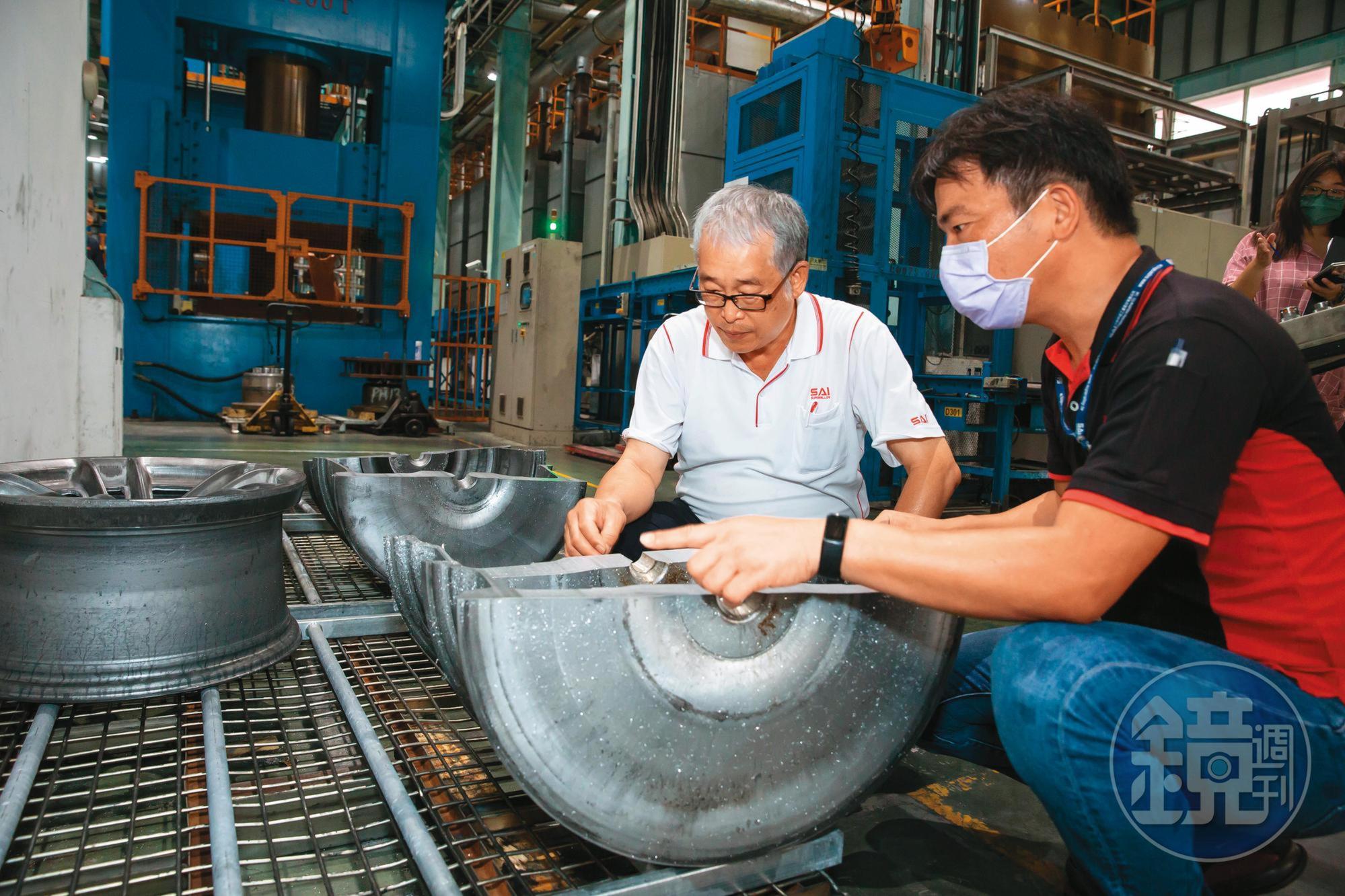 黃聰榮(左)重視製程基本功與細節,巡廠時與員工一起檢查經過粗鍛、細鍛的輪圈厚薄度是否符合設定範圍。
