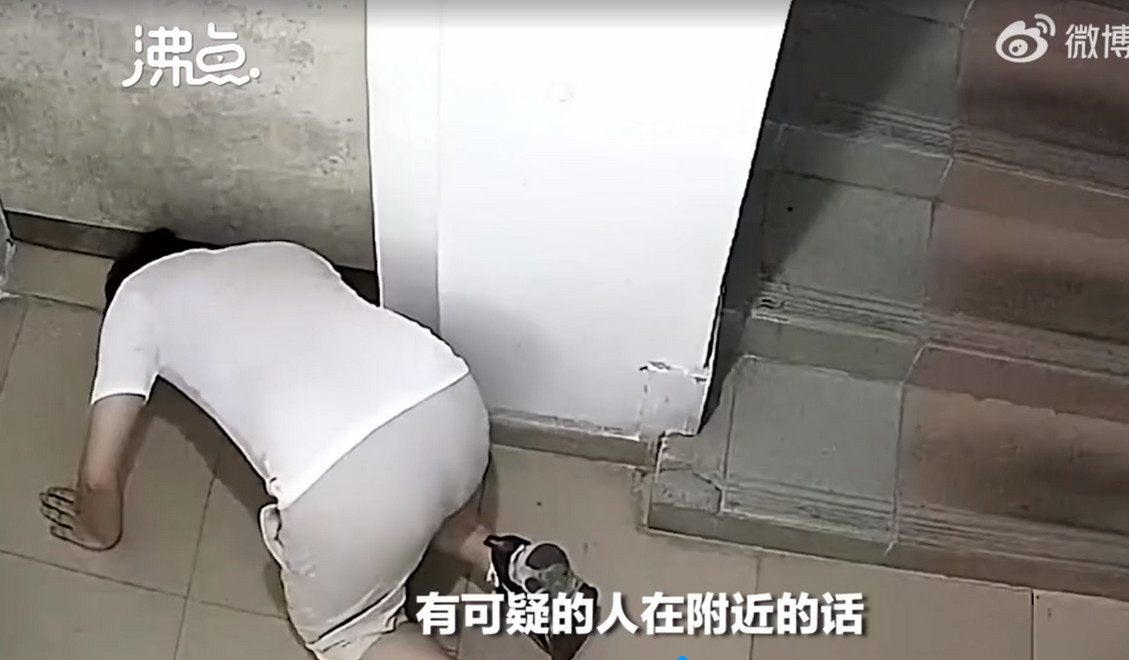中國廣東省男子深夜趴在地上從門縫偷窺房內動靜。（翻攝自《沸點視頻》）