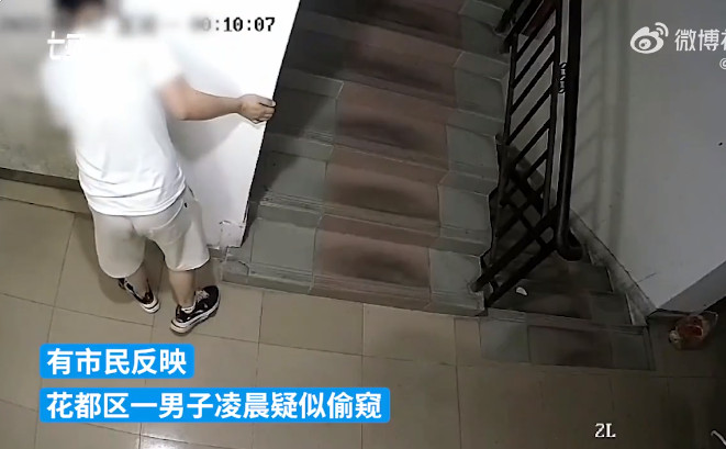 男子深夜貼在住戶門上偷聽。(翻攝自《沸點視頻》)